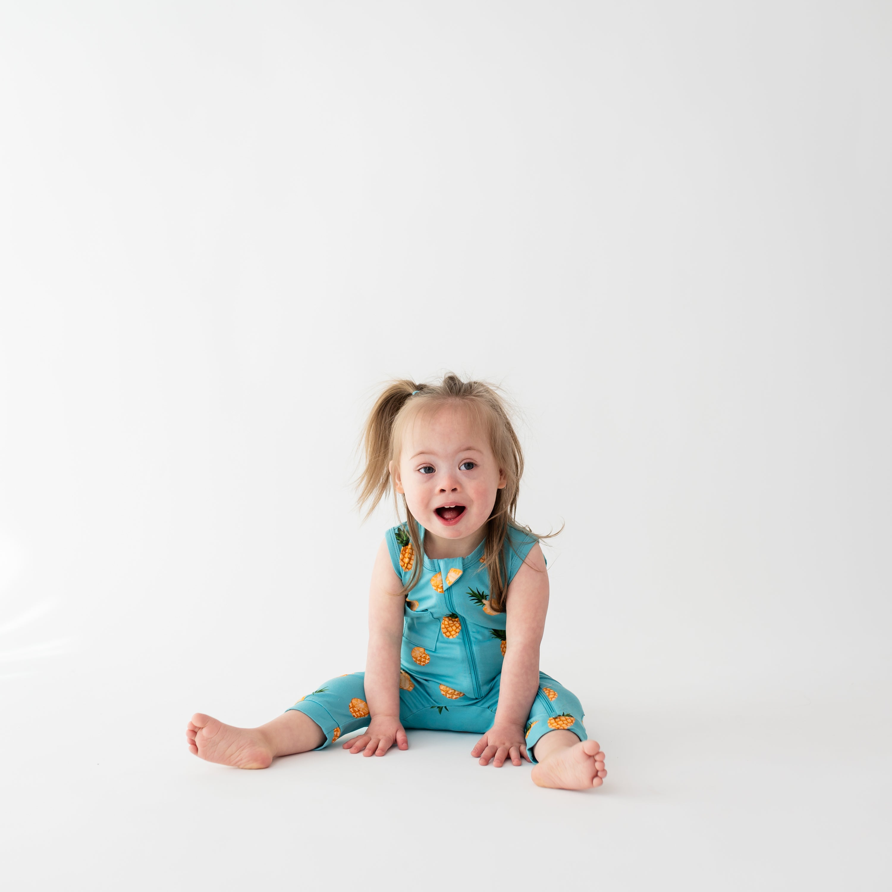 Toddler wearing Kyte Baby Sleeveless Zippered Romper in Pineapple