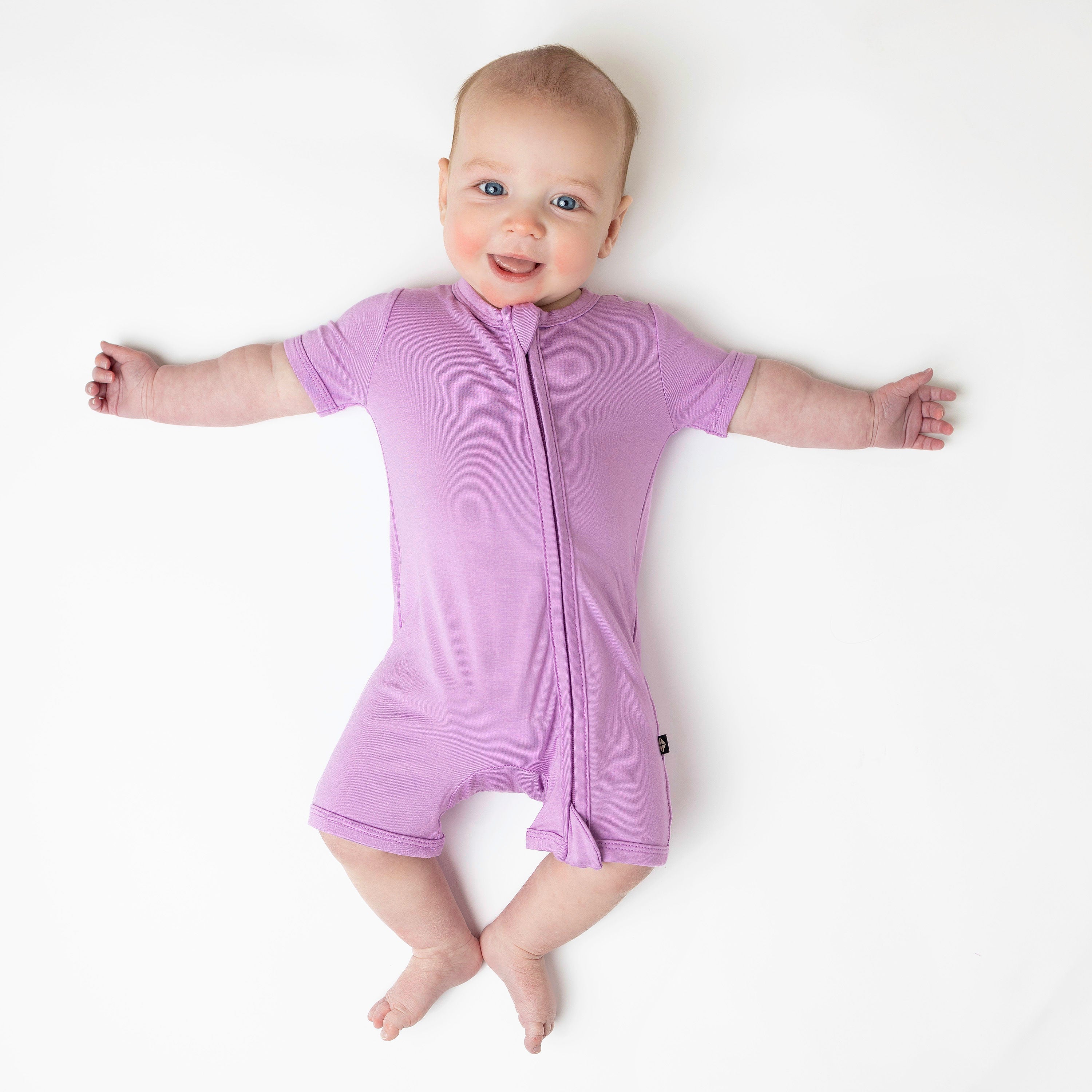 Infant wearing Kyte Baby Zippered Shortall Romper in Poi