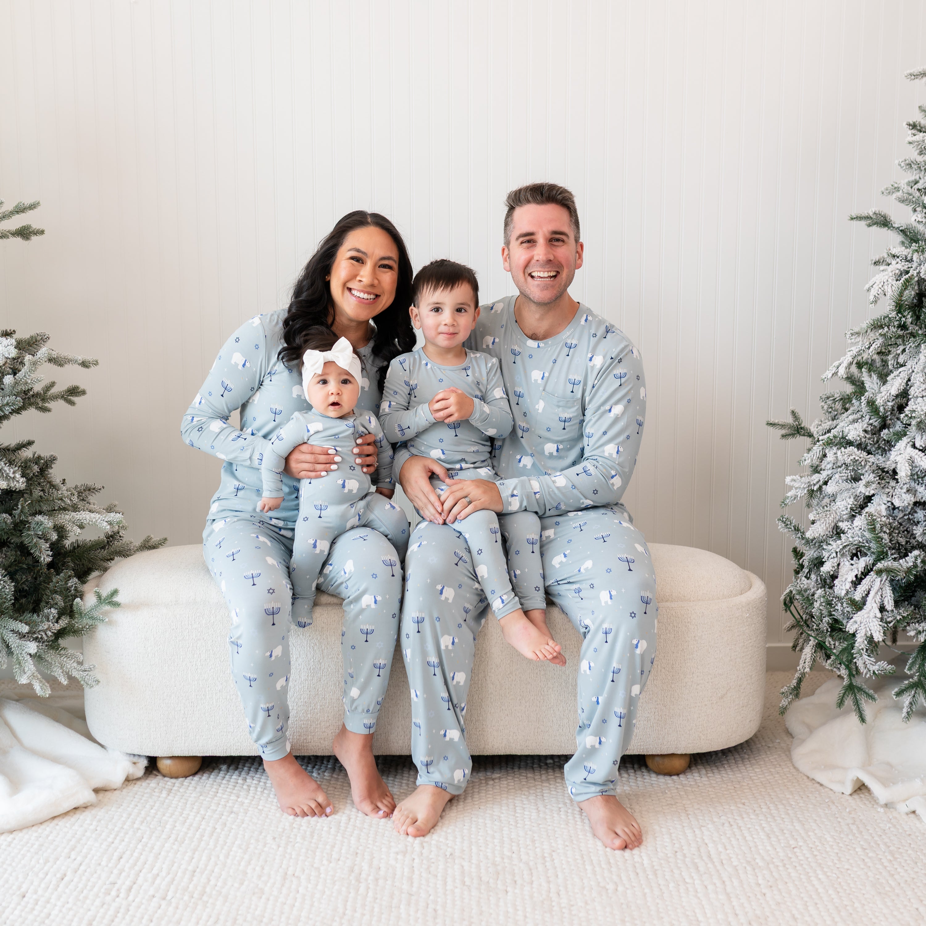 Family of four sitting on a cream ottoman all matching in Polar Lights