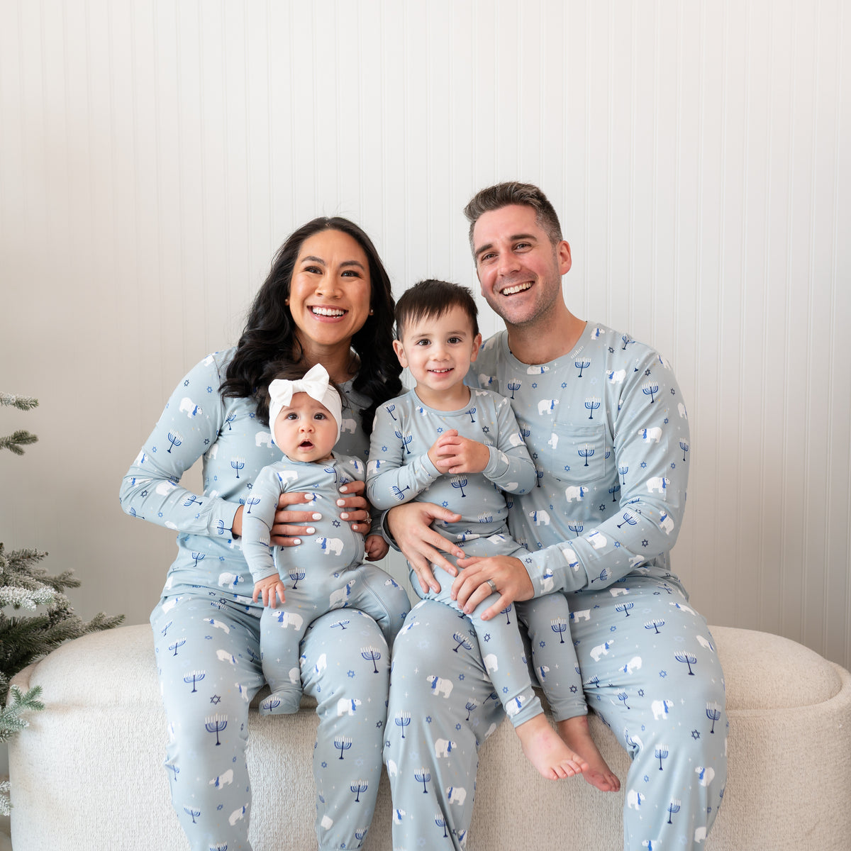 Family of four sitting on a cream ottoman matching in the Polar Lights print