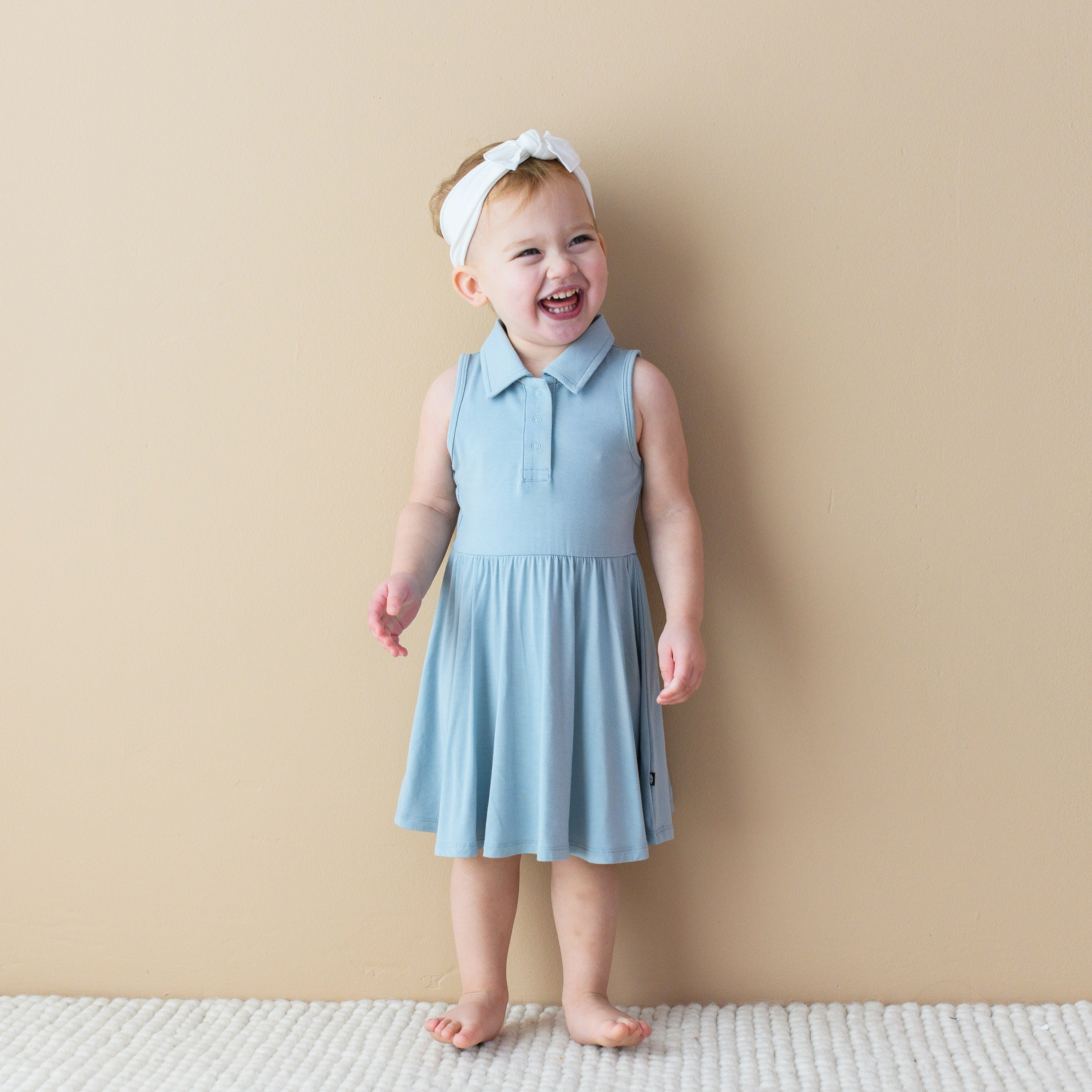 Smiling toddler modeling Polo Bodysuit Dress in Fog