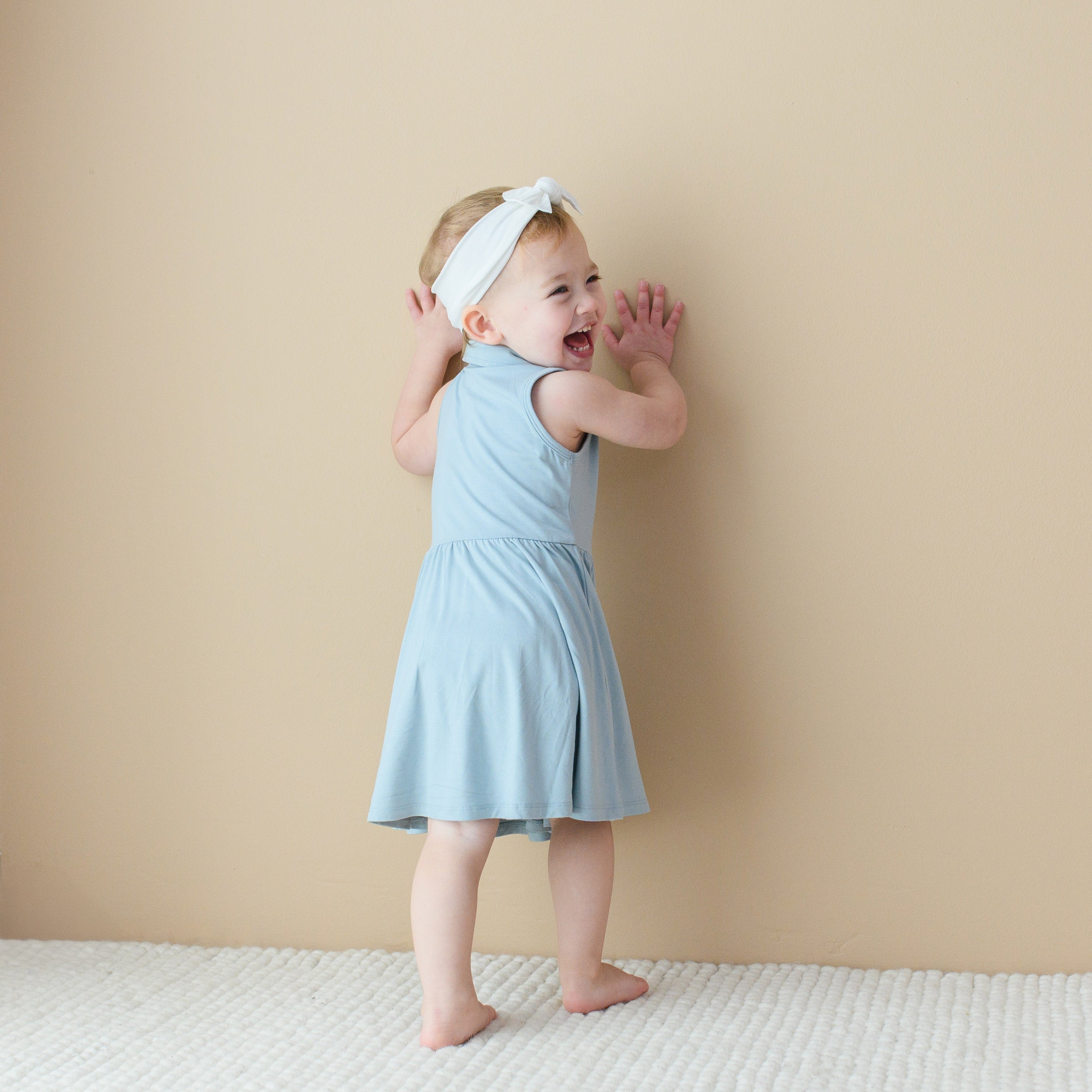 Toddler modeling the back of the Polo Bodysuit Dress in Fog