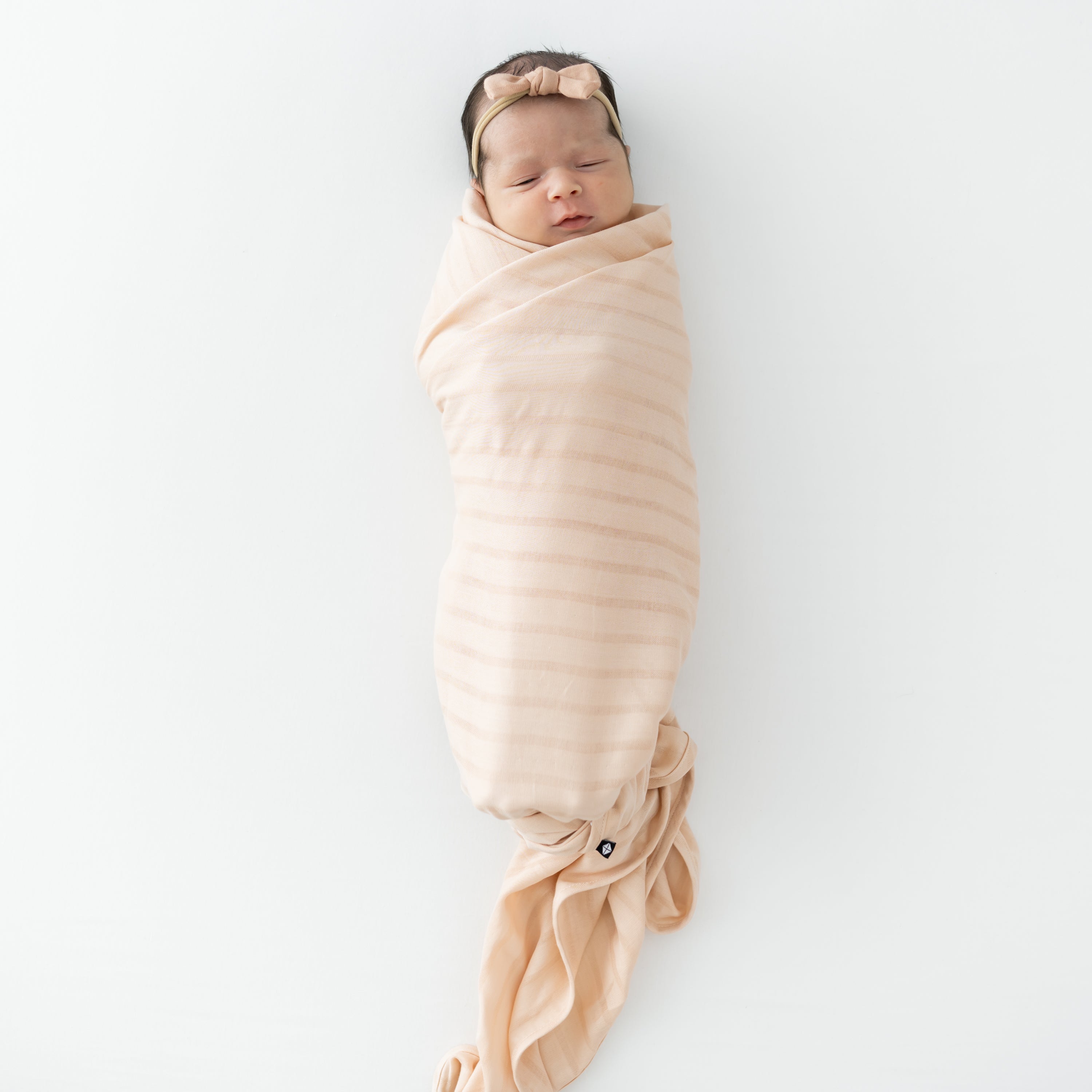 Baby wrapped in Bamboo Muslin Swaddle Blanket in Porcelain with Matching Bow