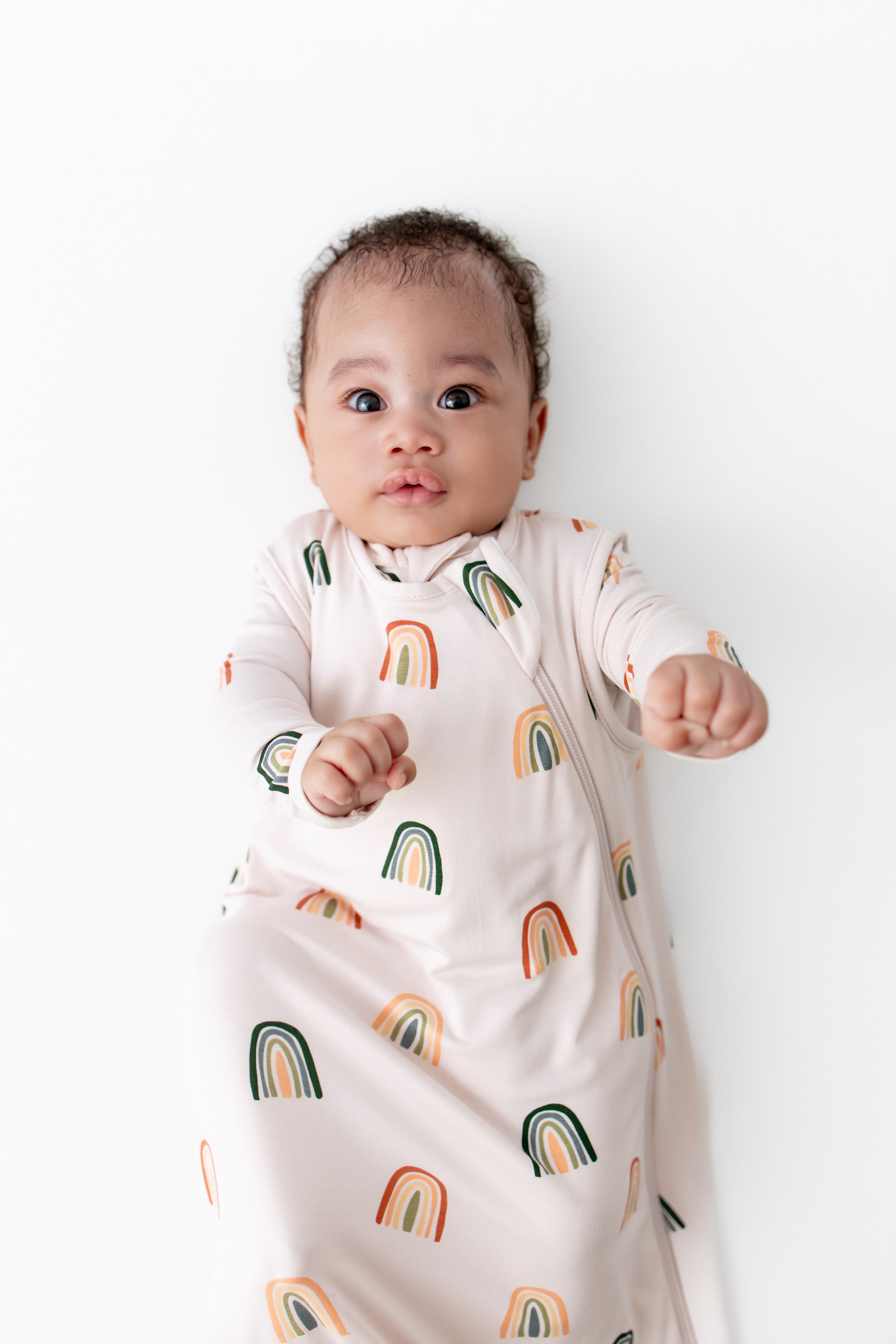 Baby wearing Sleep Bag with Retro Rainbow 0.5 print on a white background