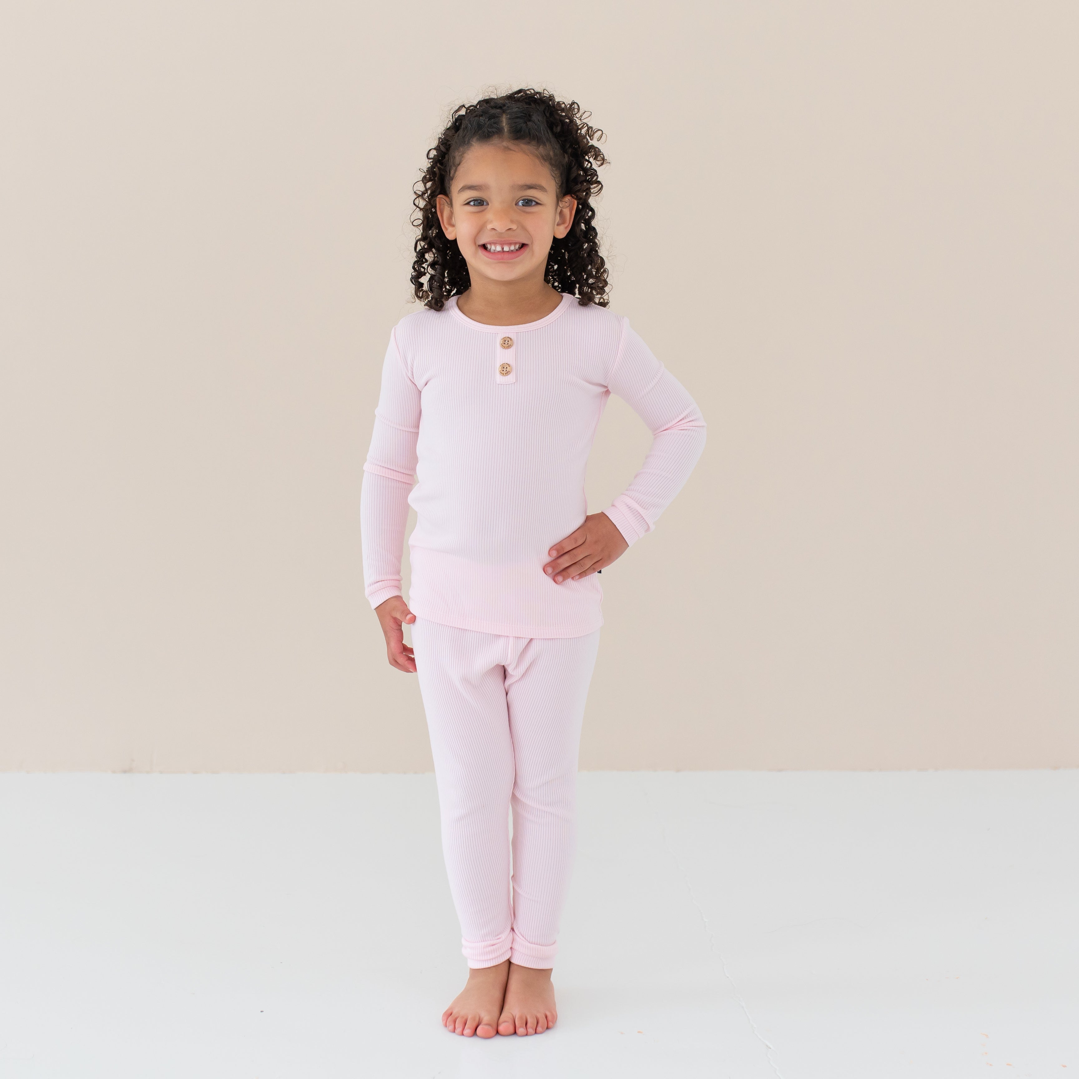 Toddler modeling Ribbed Henley Set in Sakura with hand on hip