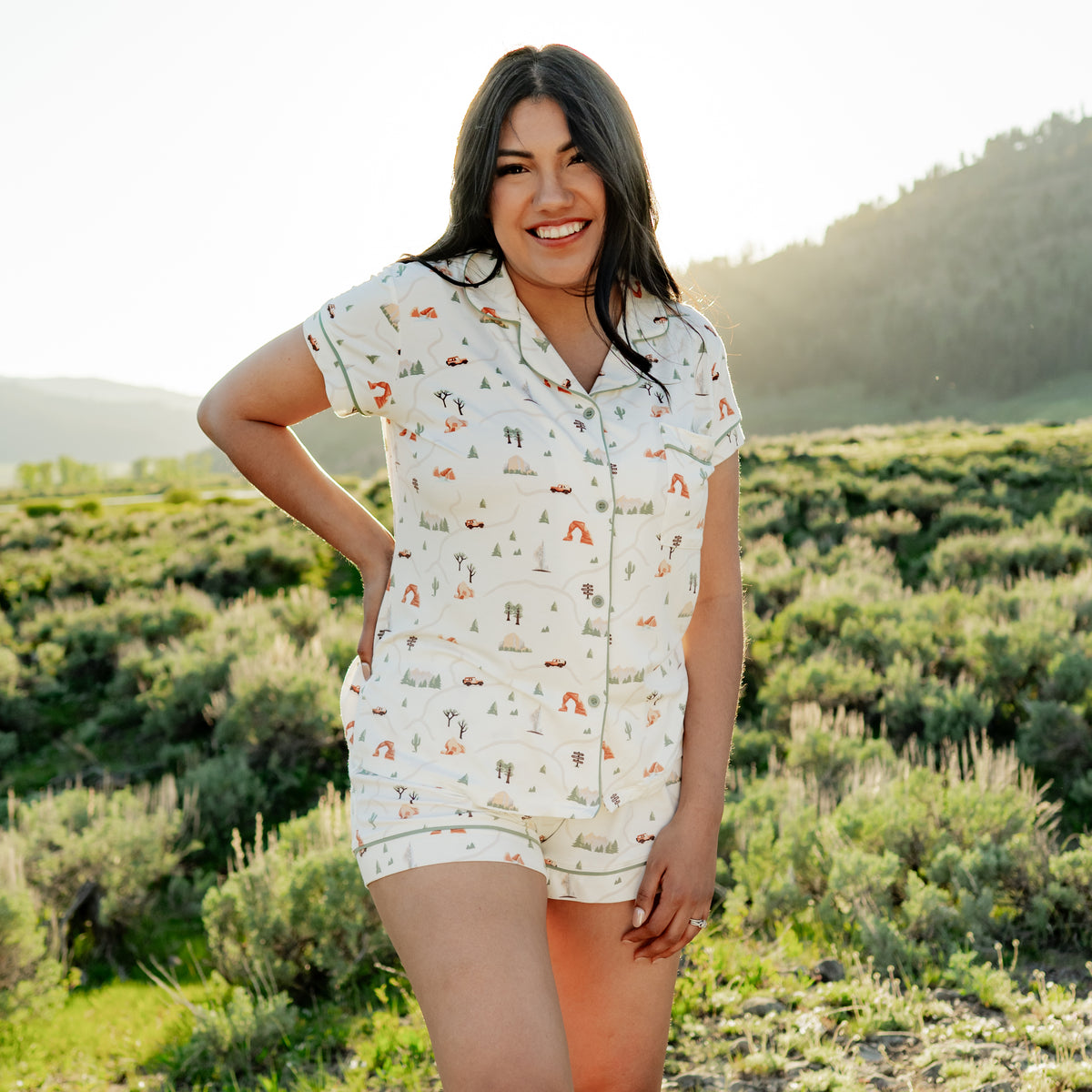 Woman modeling Women's Short Sleeve Pajama Set in Road Trip with hand on hip in Yellowstone National Park