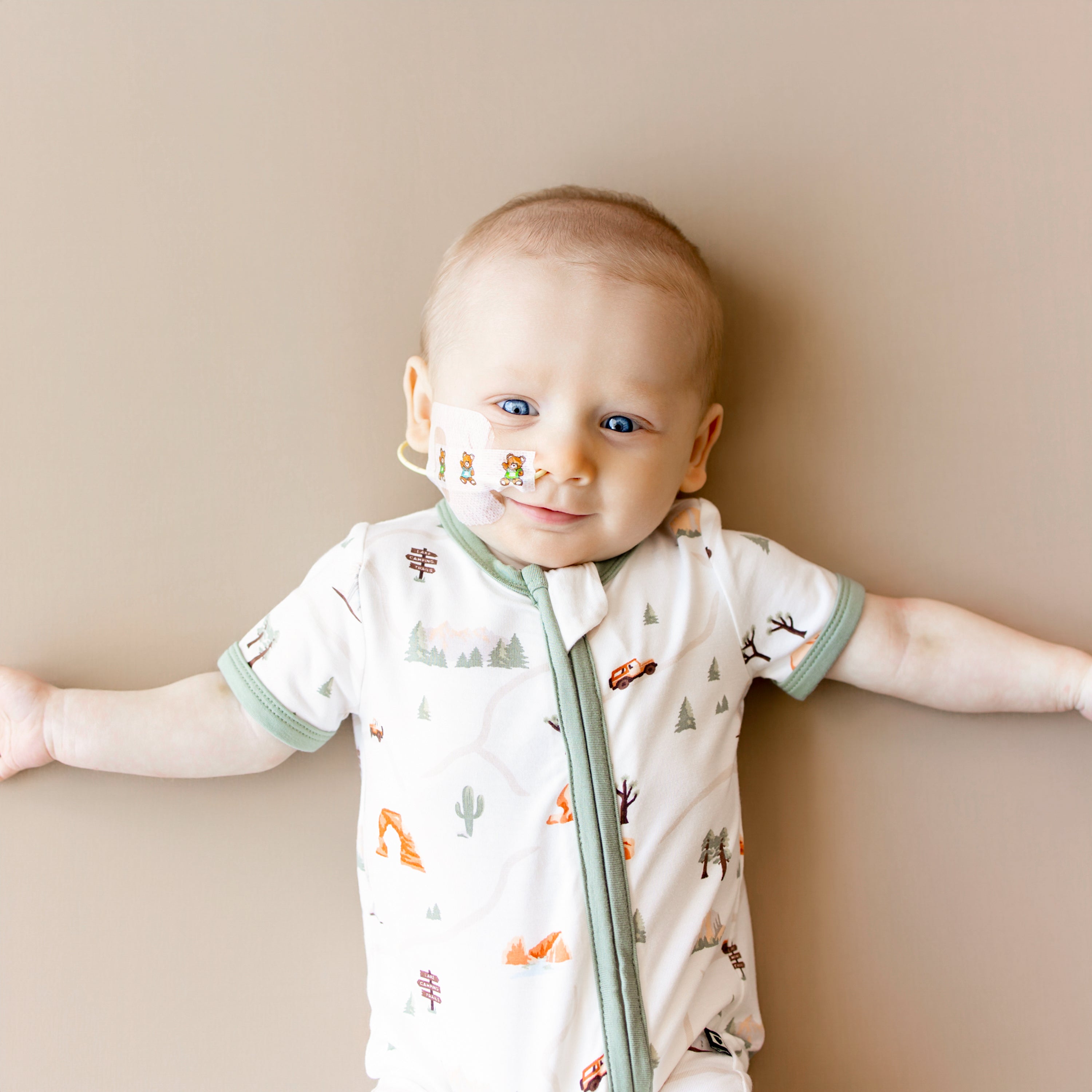 Close up of infant wearing the Zippered Shortall Romper in Road Trip