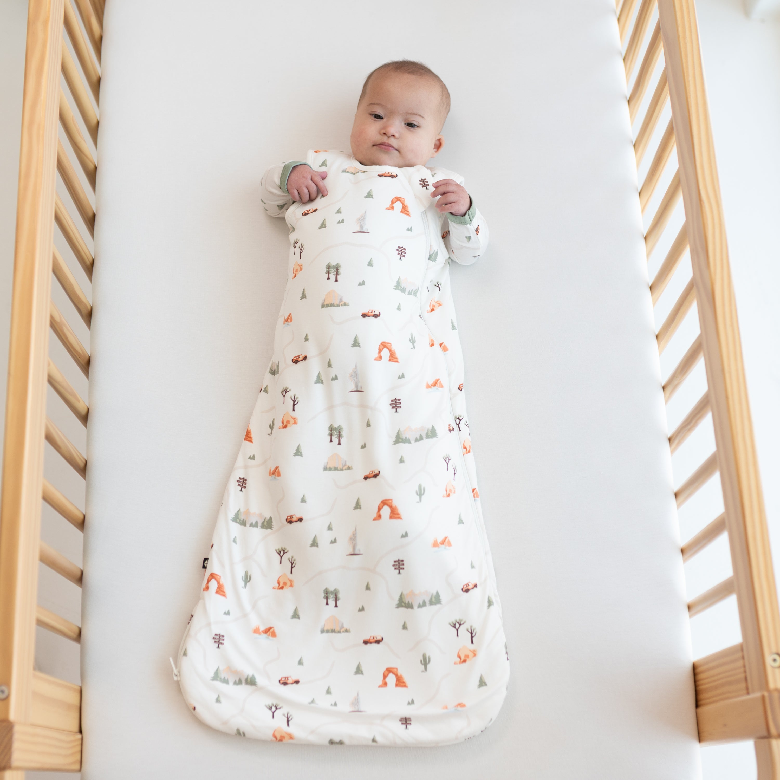 Infant wearing TOG 1.0 Sleep Bag in Roadtrip camping print