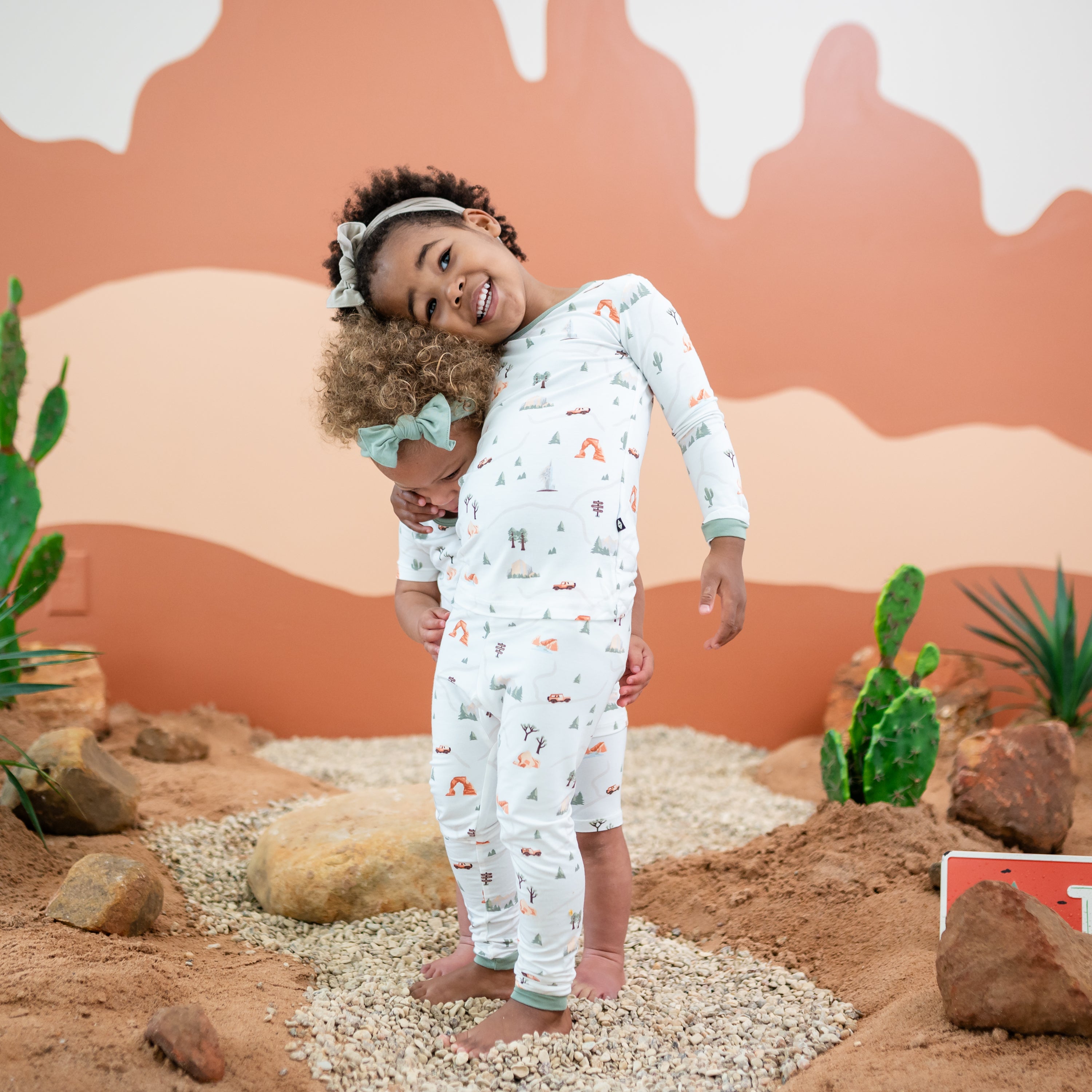 Two models hugging one another, oldest model wearing the Long Sleeve Pajamas in Road Trip with the younger model wearing the short sleeve pajama set in Road Trip