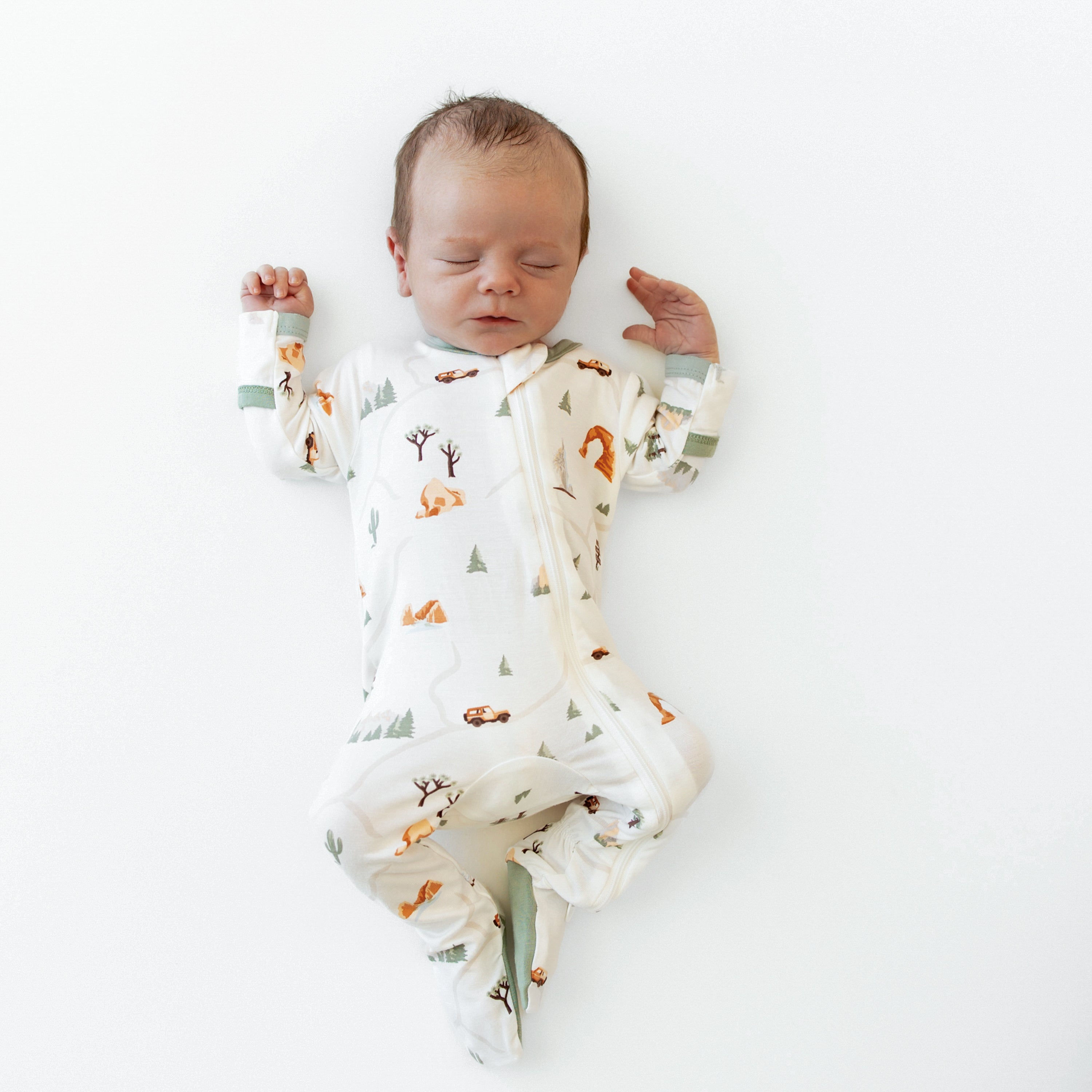 Sleeping newborn wearing Zippered Footie pajamas in Road Trip