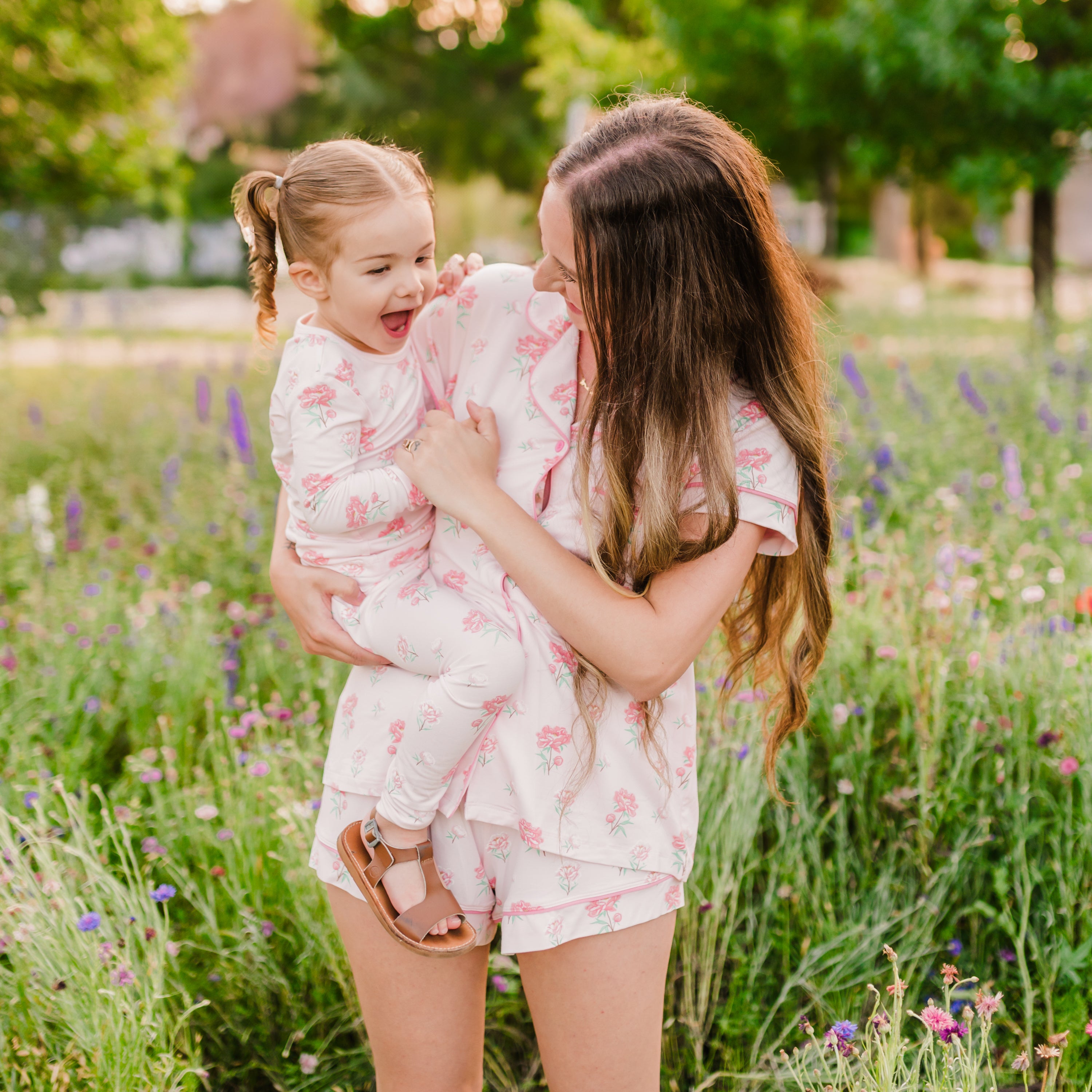 Mom in Sakura Peony Short Sleeve Pajama Set playfully holding toddler in Long Sleeve Pajamas in Sakura Peony
