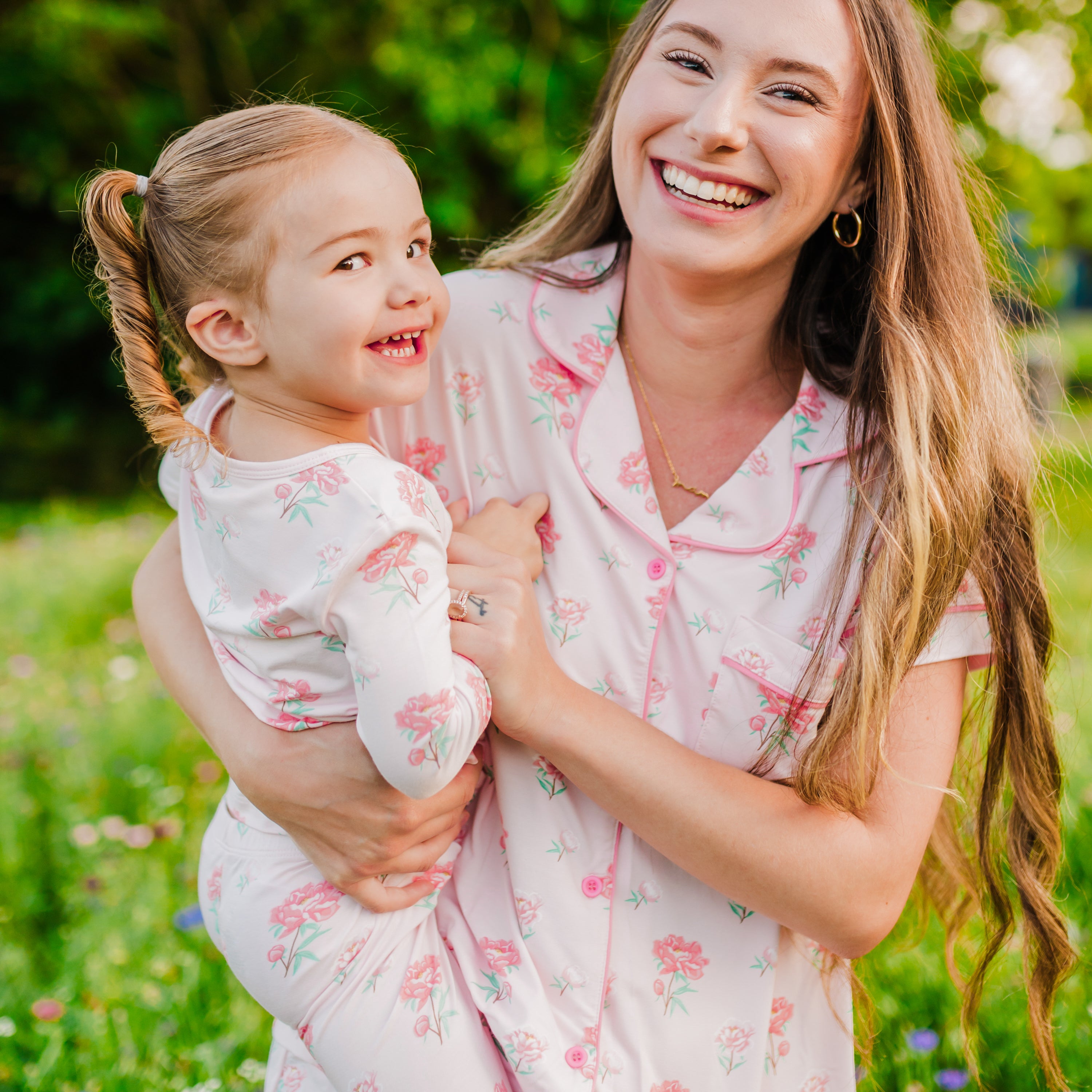 Close up of Woman wearing Women's Short Sleeve Pajama Set in Sakura Peony holding toddler in matching pajamas