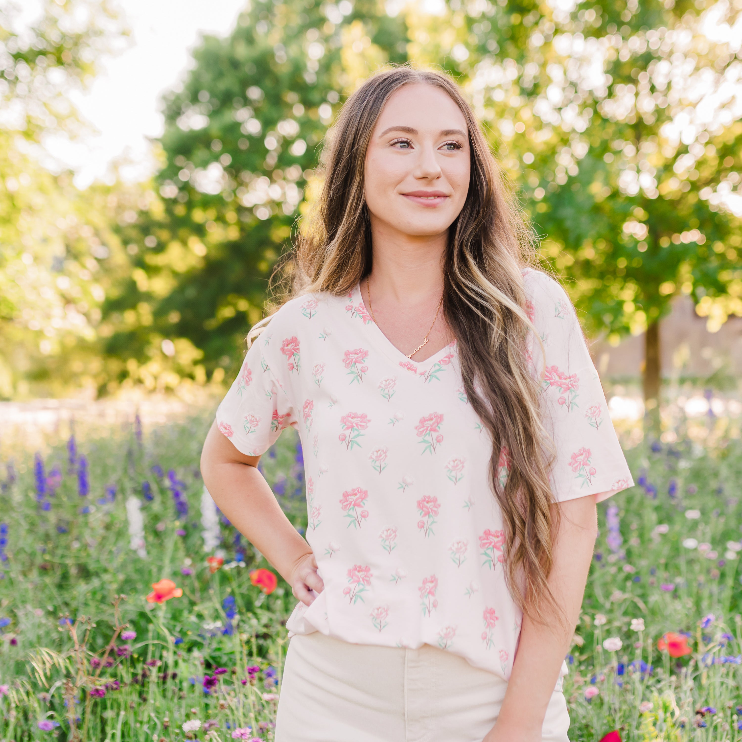 Woman modeling Women's Relaxed Fit V-Neck in Sakura Peony in a wildflower field