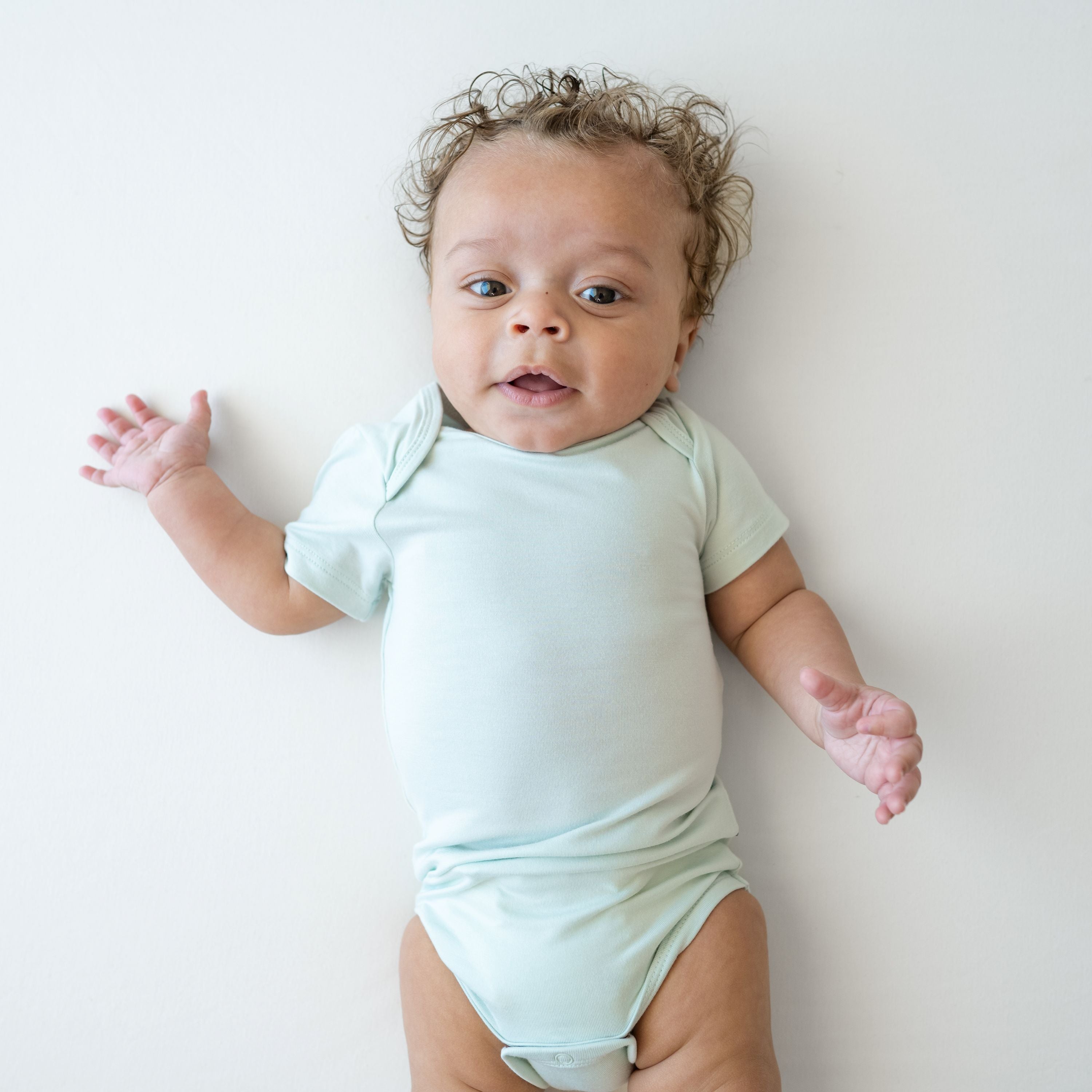 Close up of infant model wearing the Bodysuit in Dew