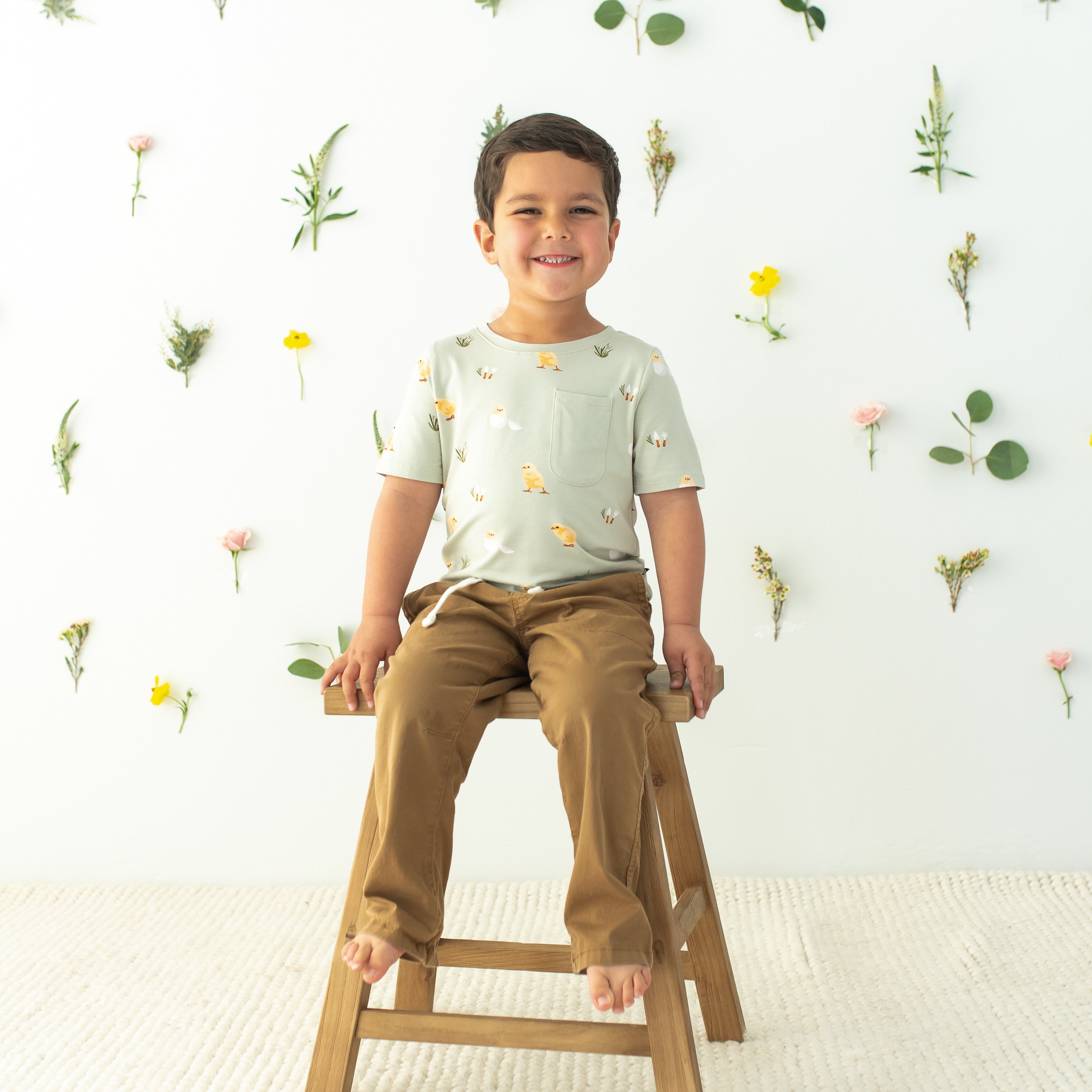 Toddler sitting on stool wearing Toddler Crew Neck Tee in Aloe Chick