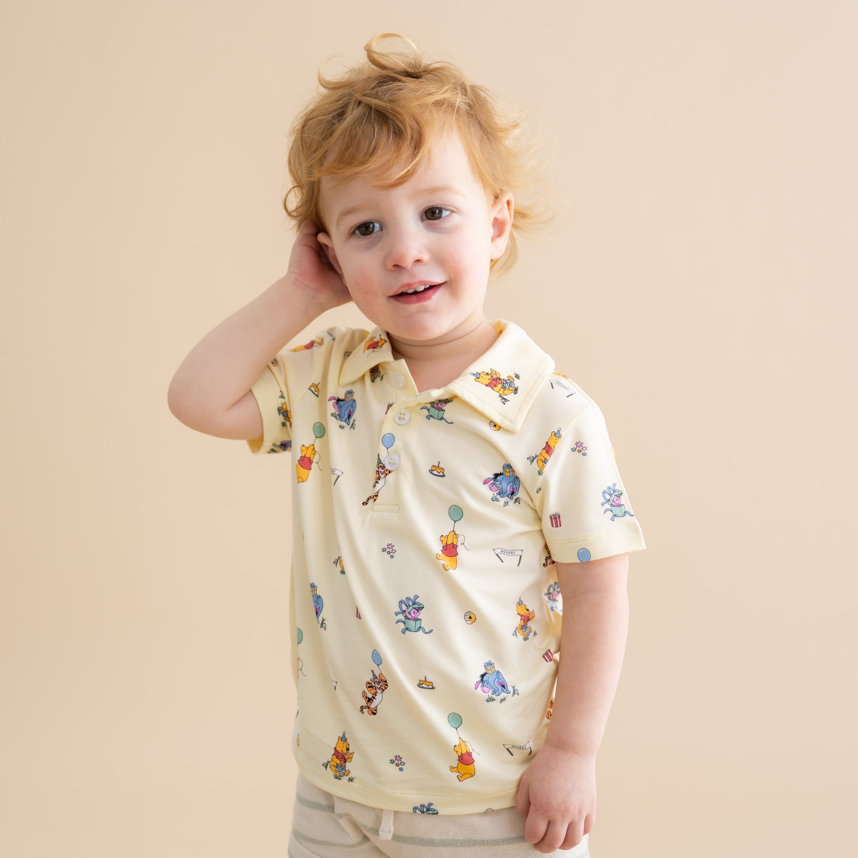 Young toddler wearing the Toddler Short Sleeve Polo in Winnie the Pooh Celebration