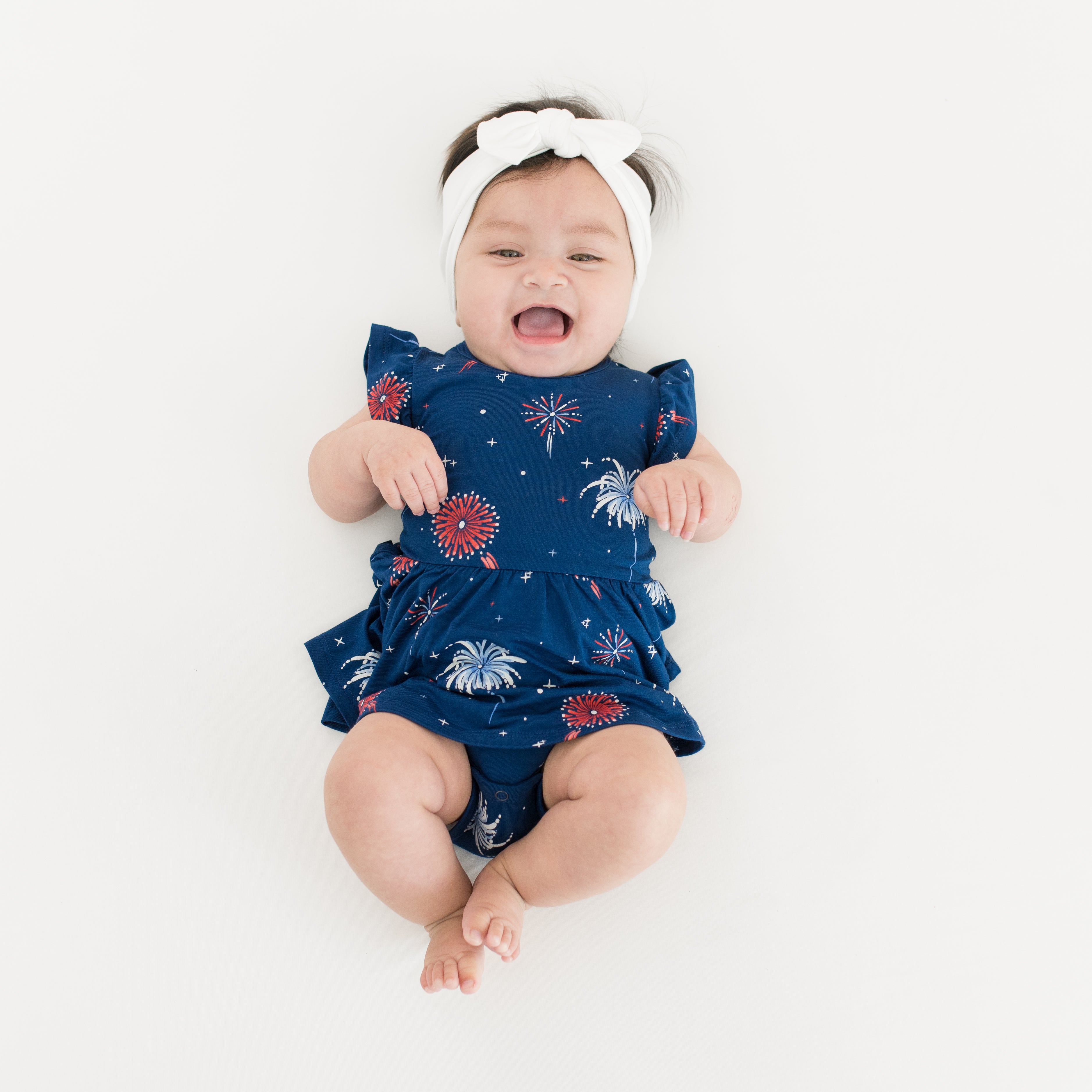 Baby smiling wearing Twirl Bodysuit Dress in Celebration with a Cloud Bow