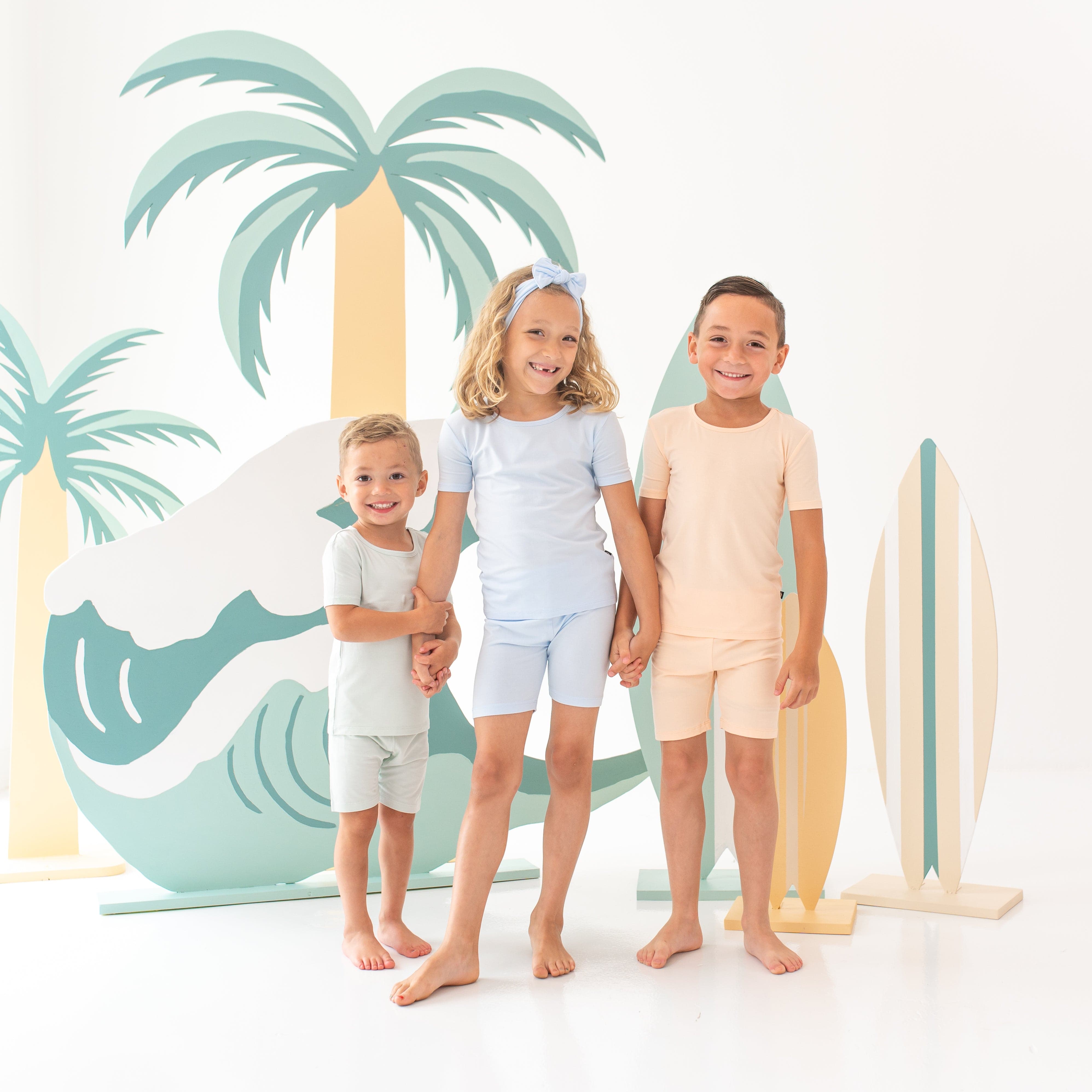 Three models holding hands wearing the Short Sleeve Pajama Sets in Summer Solid colors