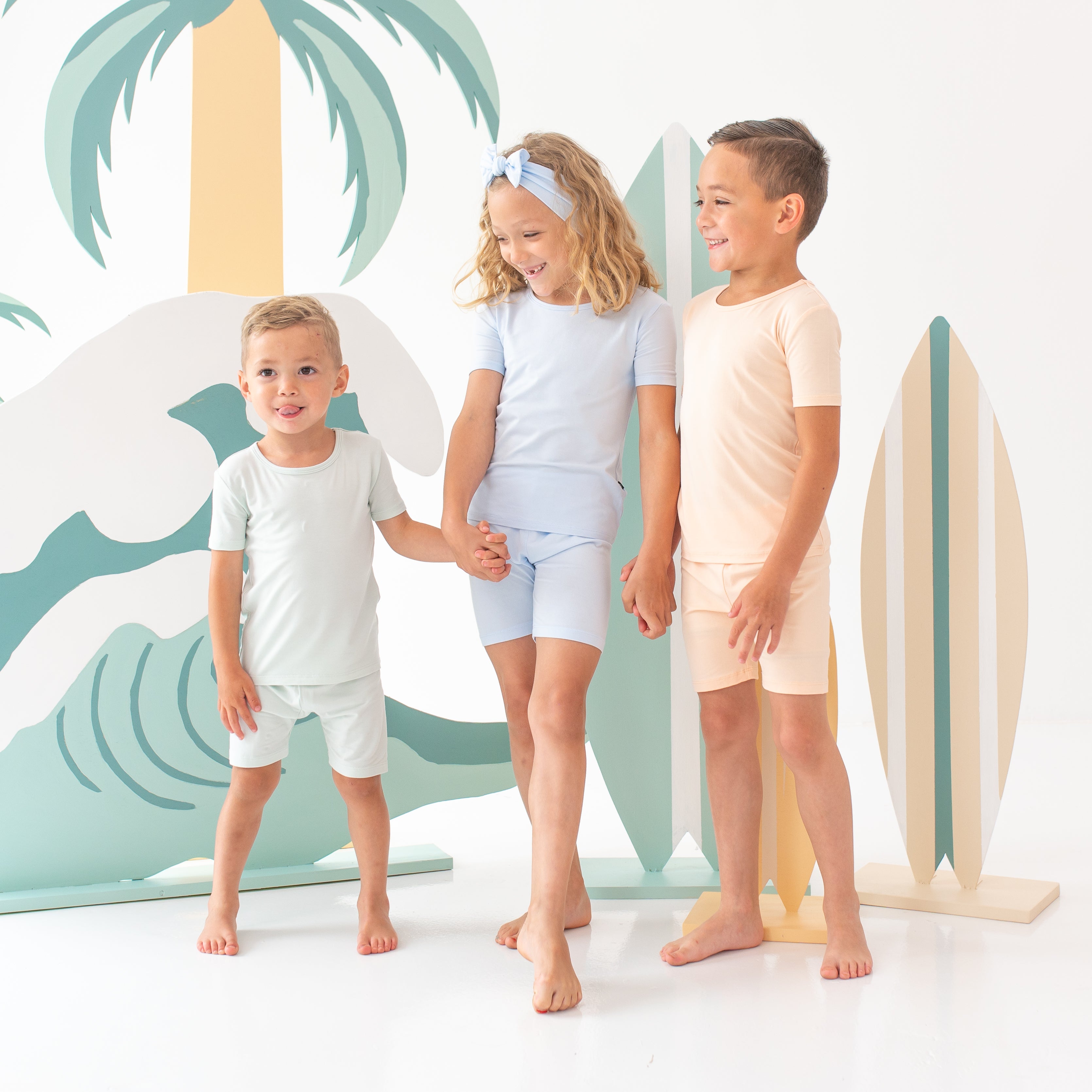 Group shot of children models holding hands wearing the Short Sleeve Pajama Sets in Summer Solids