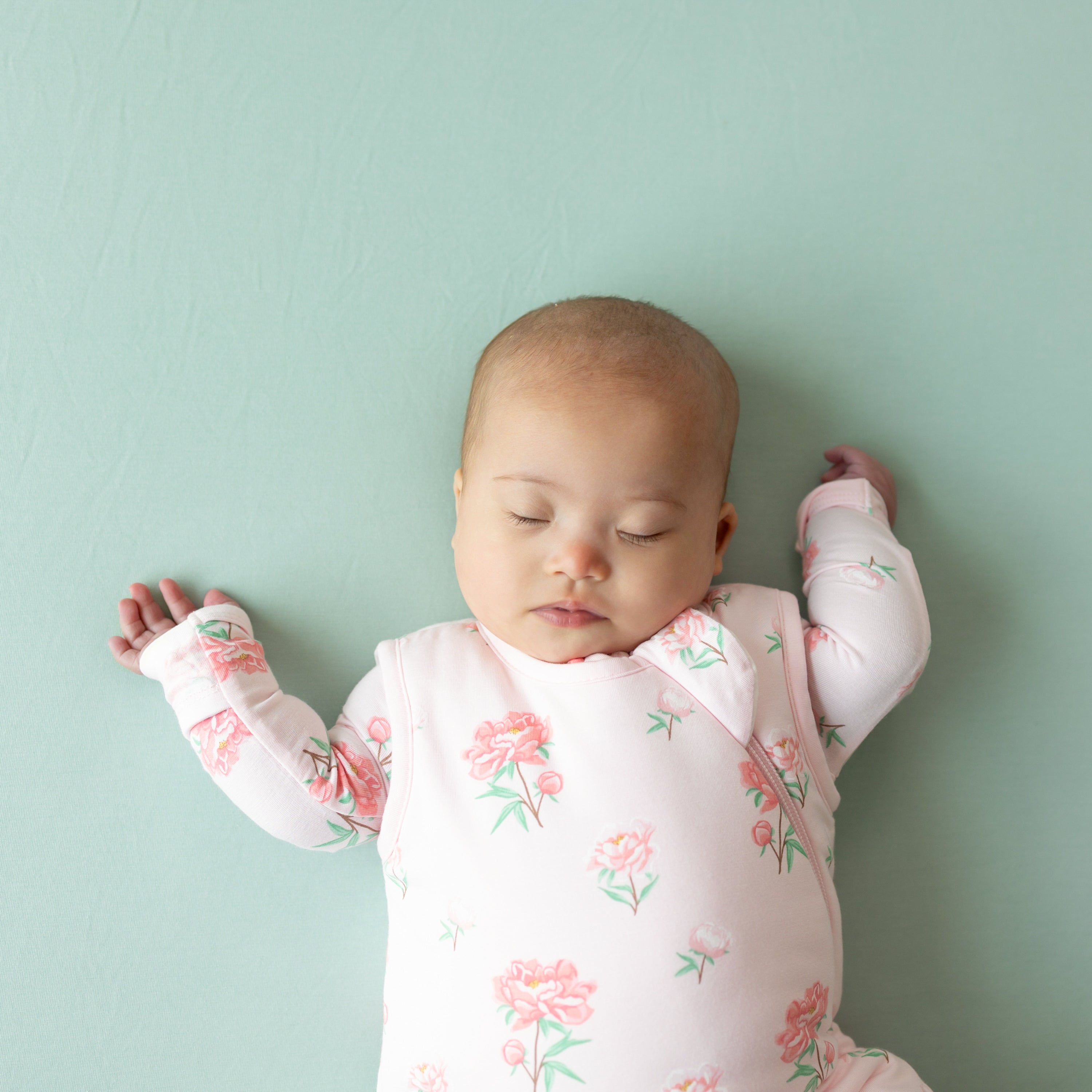 Close up of sleeping baby wearing the Sleep Bag in Sakura Peony