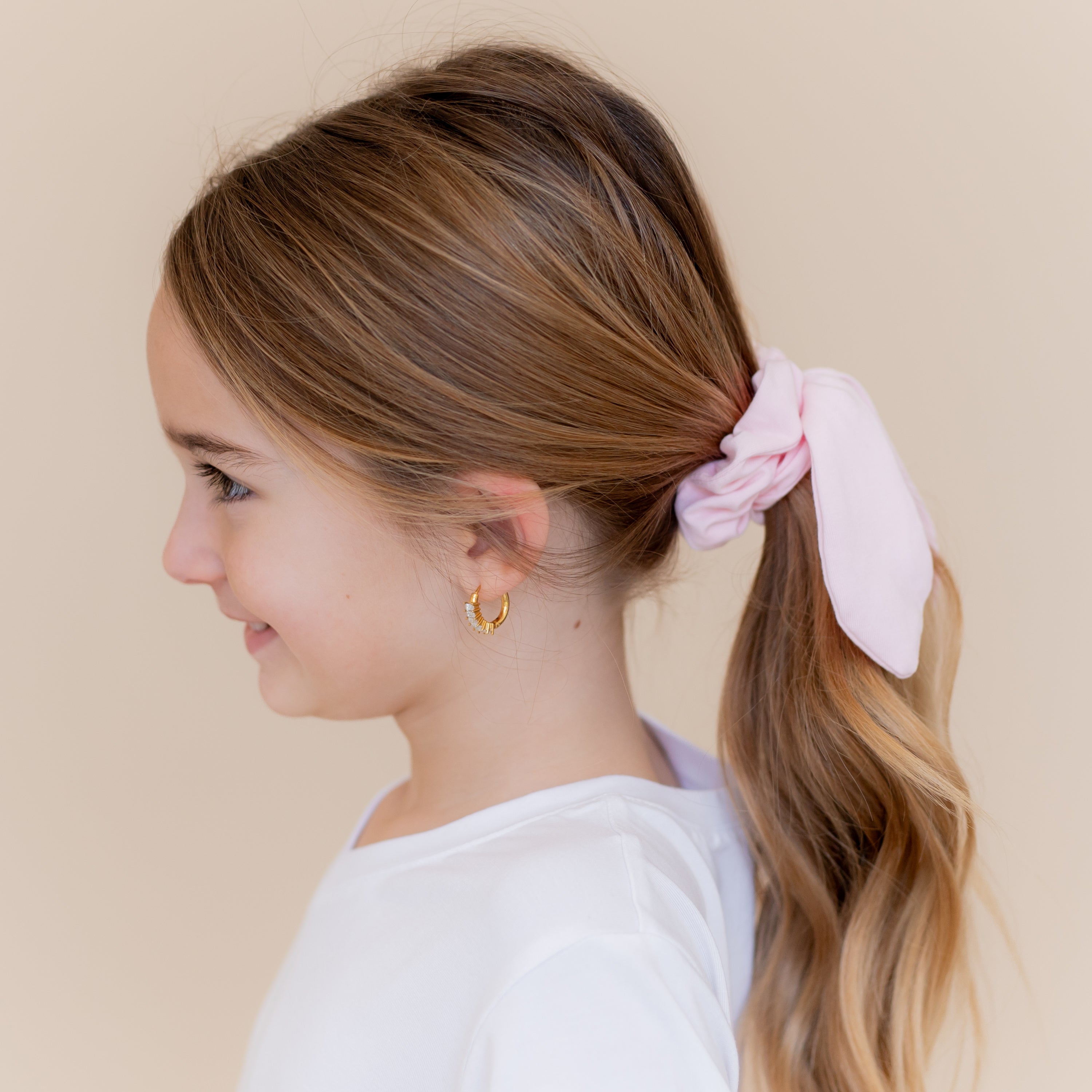 Scrunchie in Sakura shown in a young girls ponytail