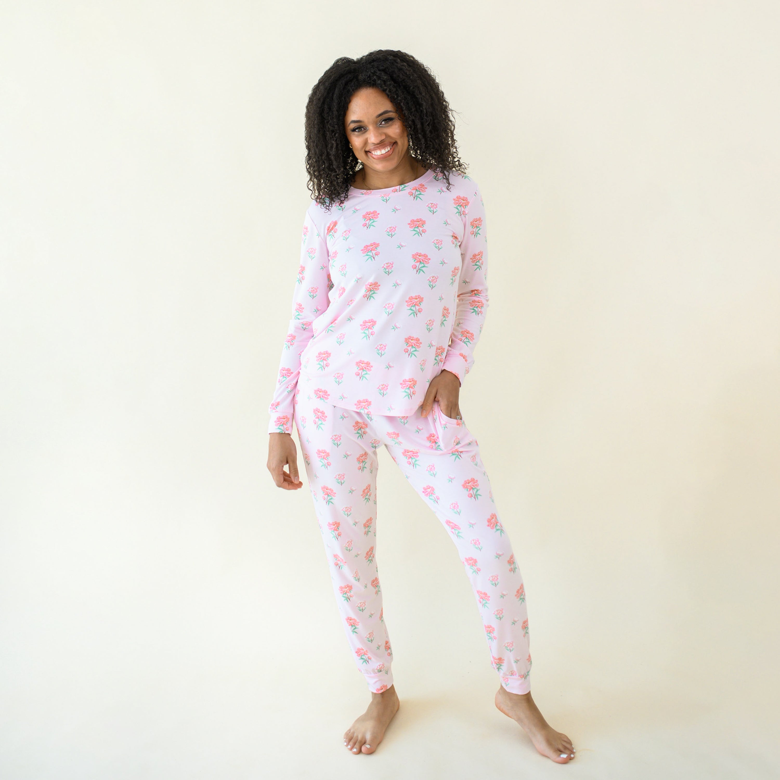 Smiling model wearing the Women's Jogger Pajama Set in Sakura Peony with one hand in the jogger bottoms pocket
