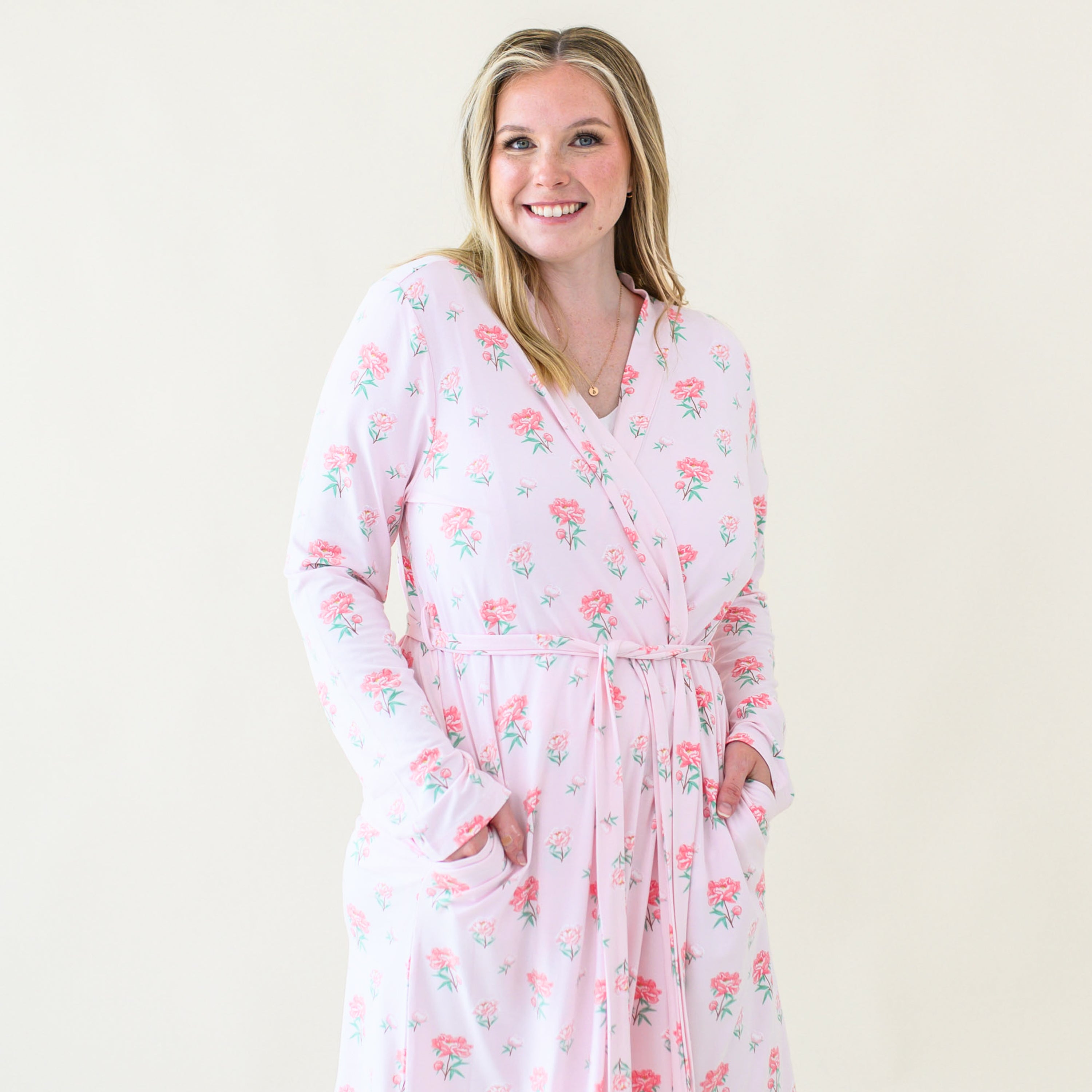 Close up of smiling model wearing the Women's Lounge Robe in Sakura Peony tied up with both hands in the pockets