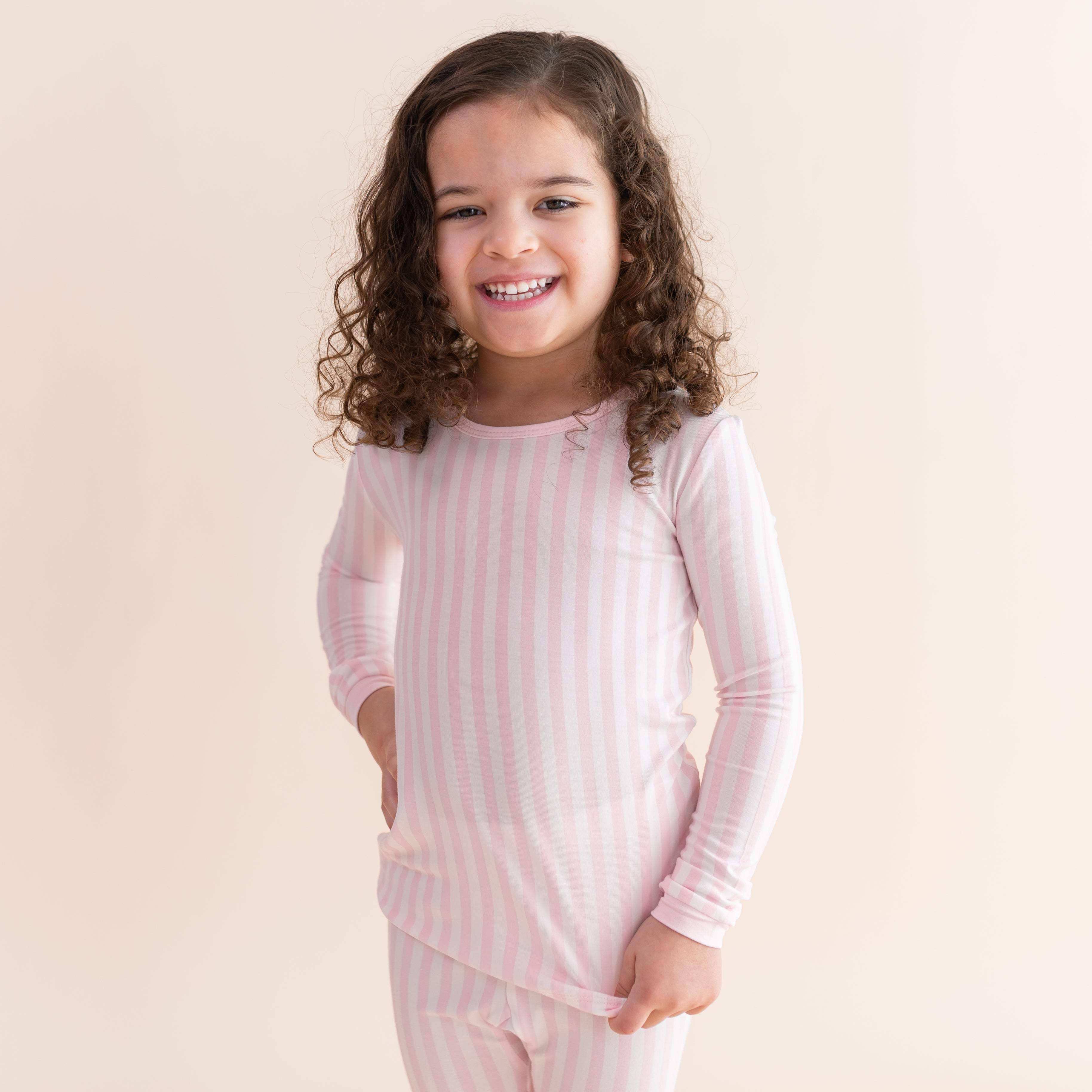 Close up of a young girl wearing the soft and breathable Long Sleeve Pajamas in Small Sakura Stripe