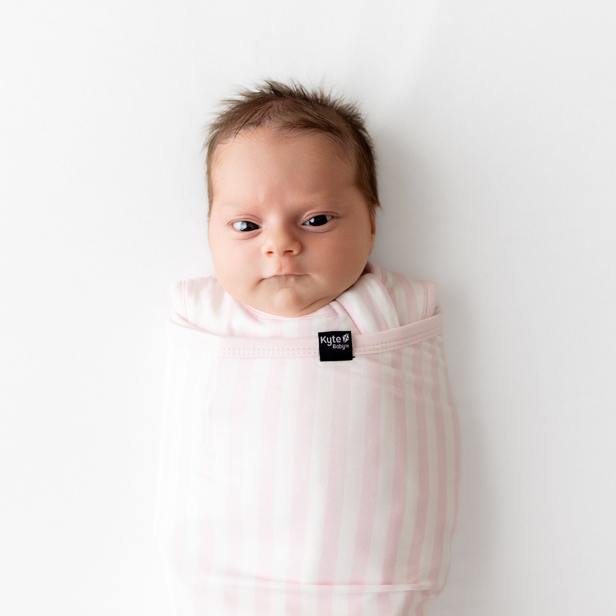 Close up of a newborn swaddled in the Sleep Bag Swaddler in Small Sakura Stripe 1.0