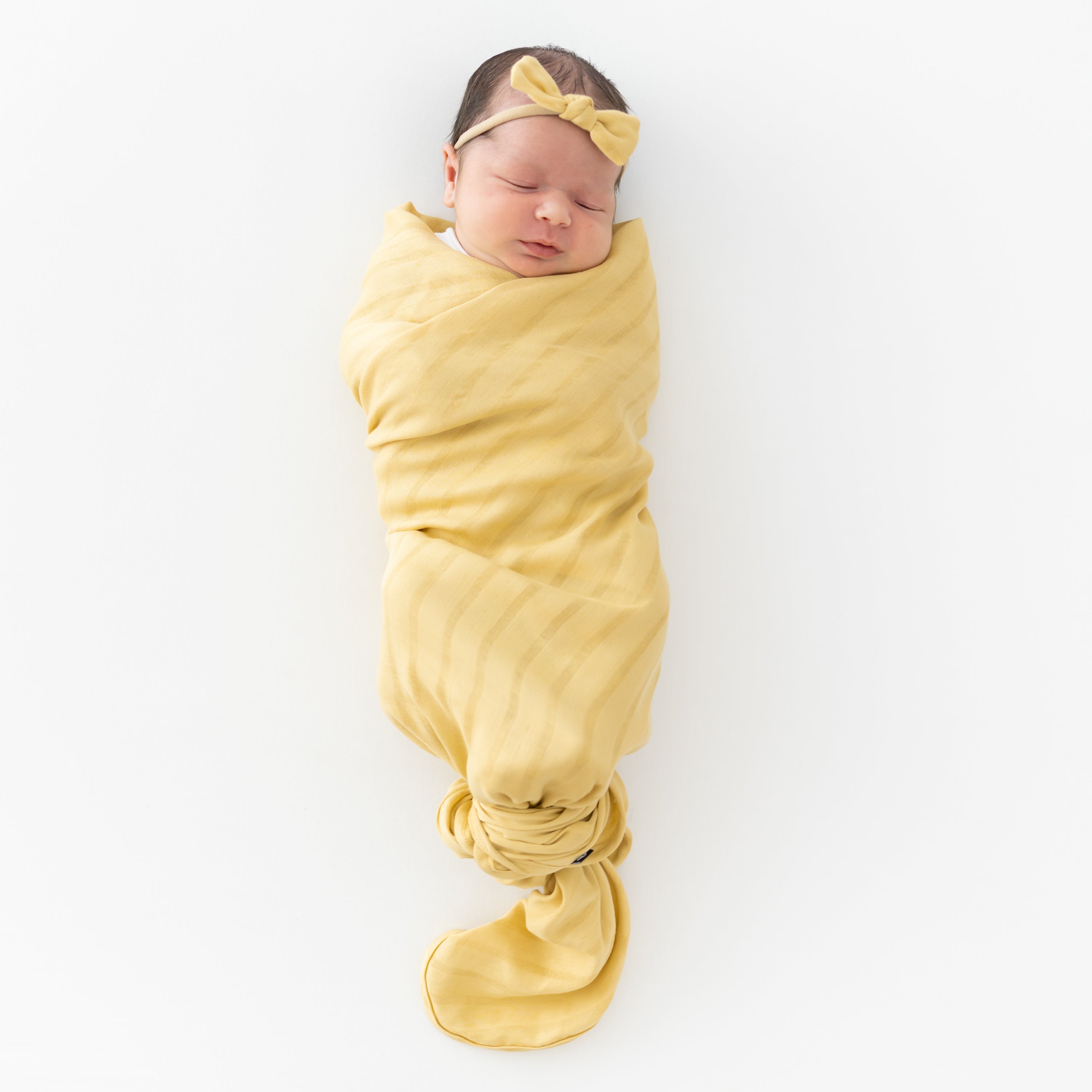 Baby swaddled in Bamboo Muslin Swaddle Blanket in Sandcastle