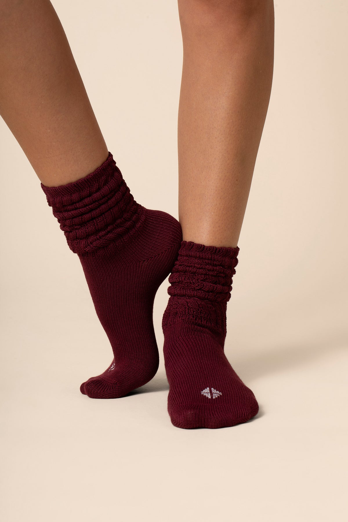 Maroon socks worn by a person on a beige background