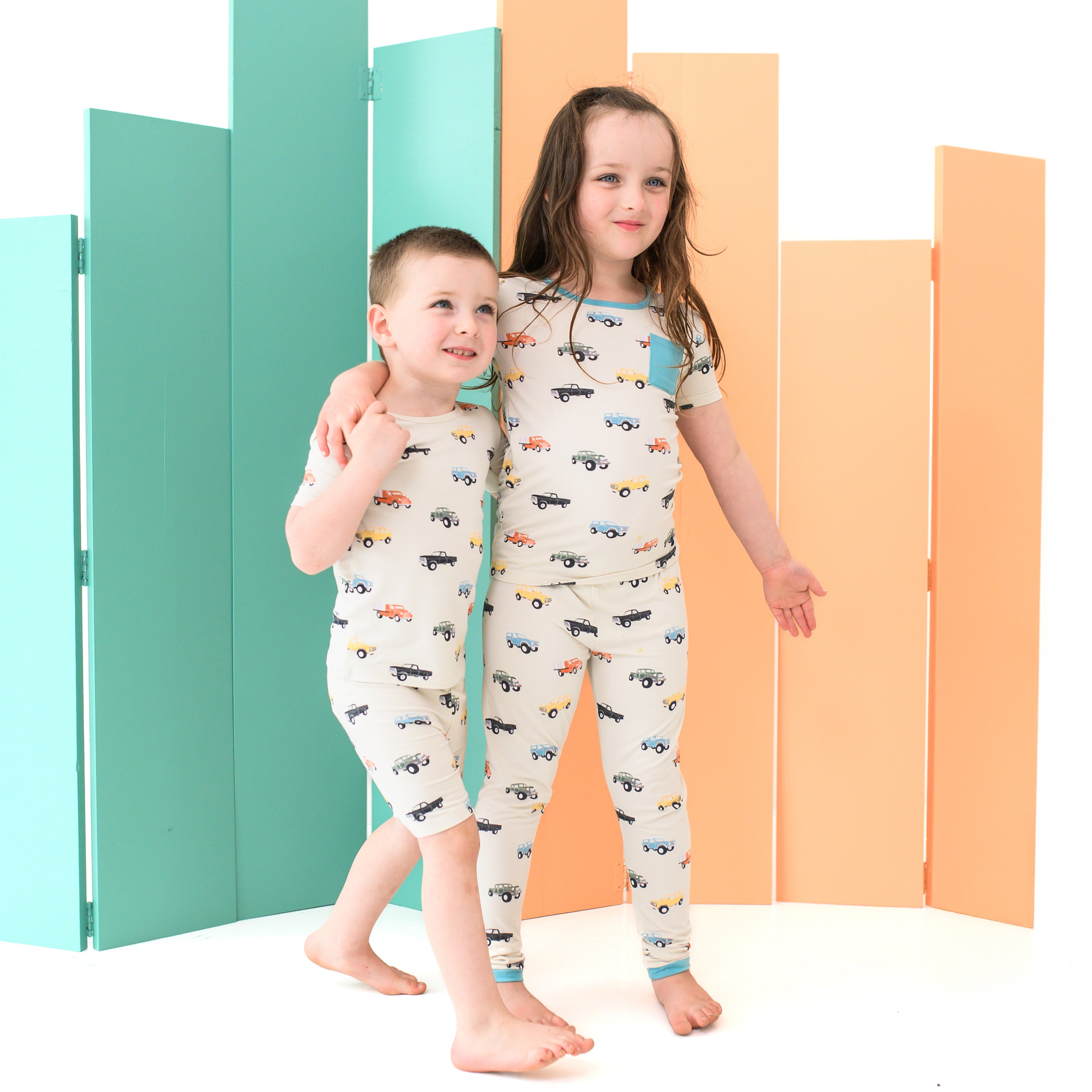 Siblings wearing Matching PJ Sets in Vintage Truck pattern