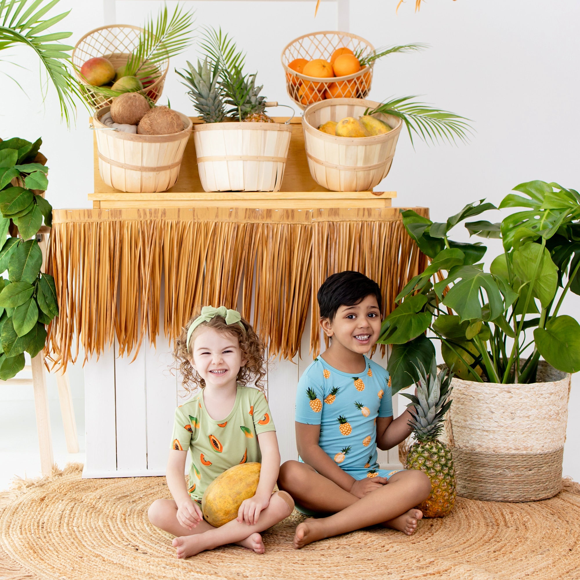 Kids wearing bamboo pajamas in papaya and pineapple prints