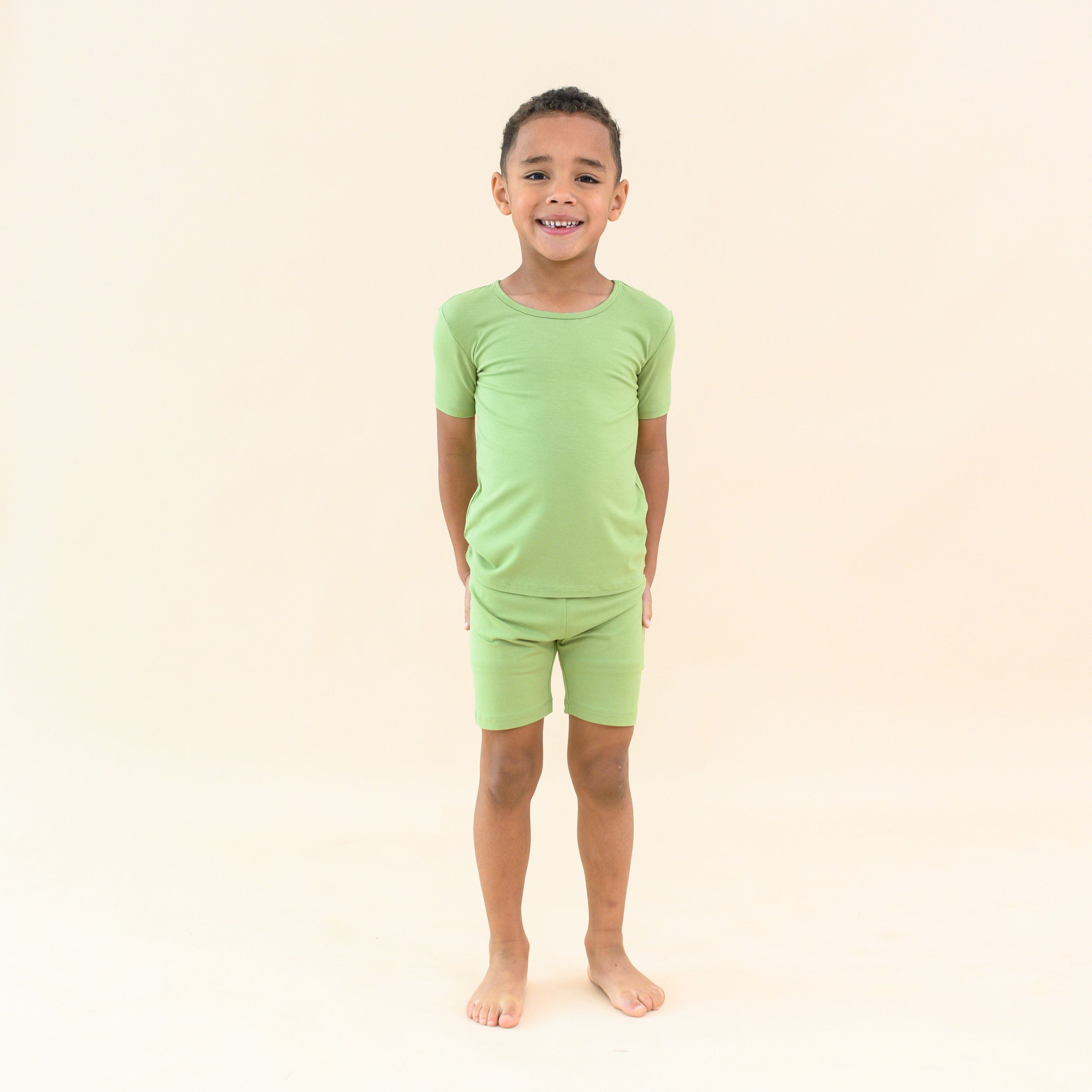Child wearing short sleeve green pajamas in honu