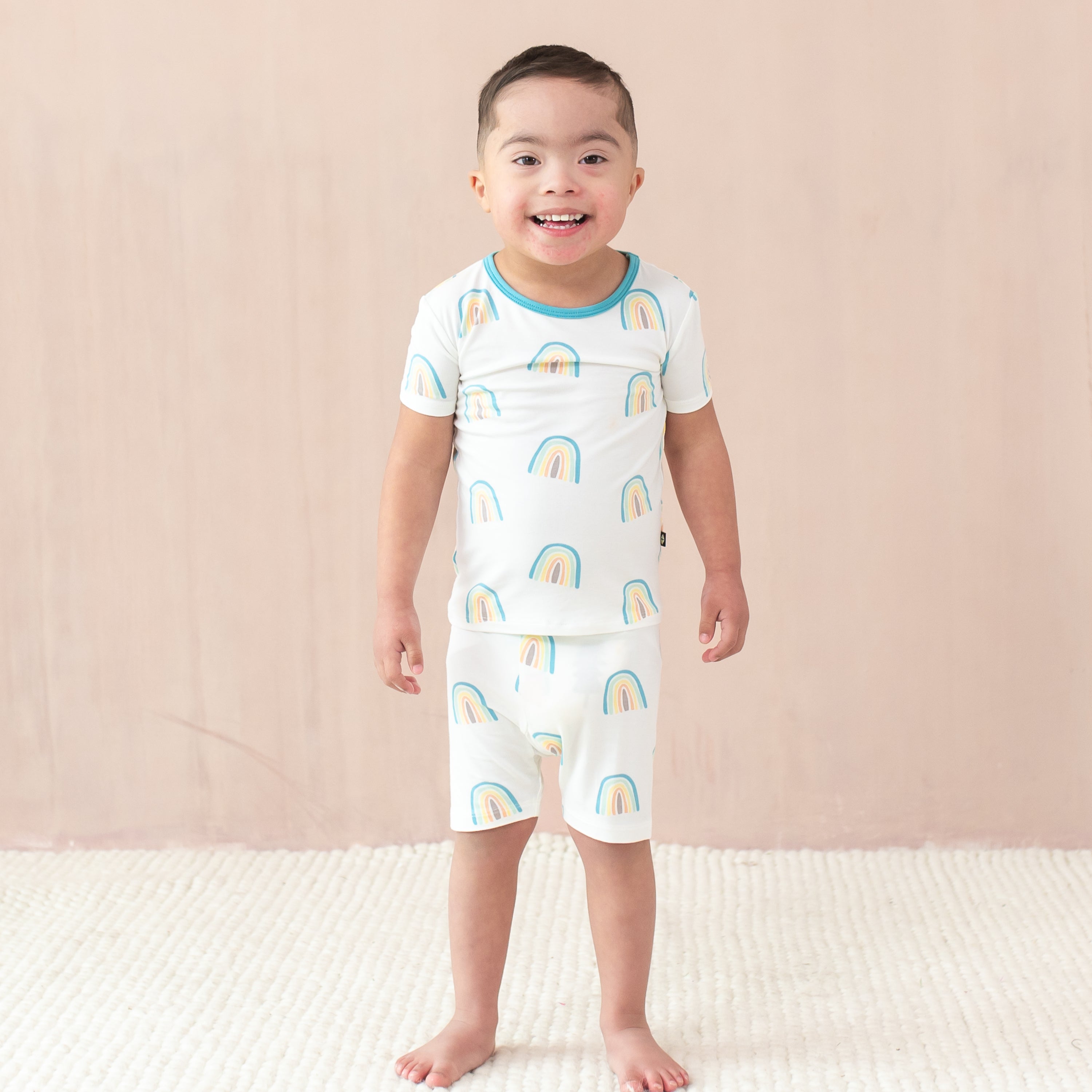 Toddler modeling Short Sleeve Pajamas in Makai Rainbow