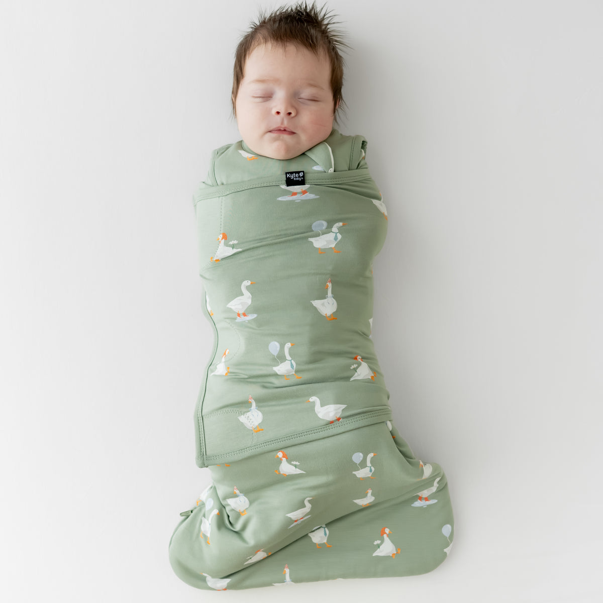 Newborn sleeping swaddled in the Sleep Bag Swaddler in Silly Goose 1.0