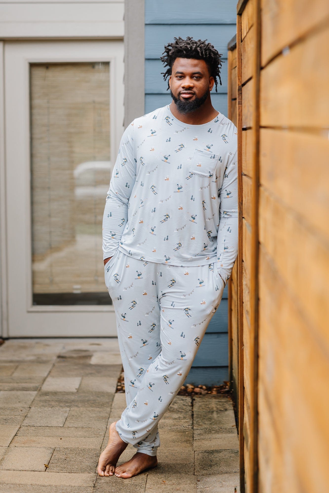 Male model wearing the Men's Jogger Set in Ski leaning against a wooden fence
