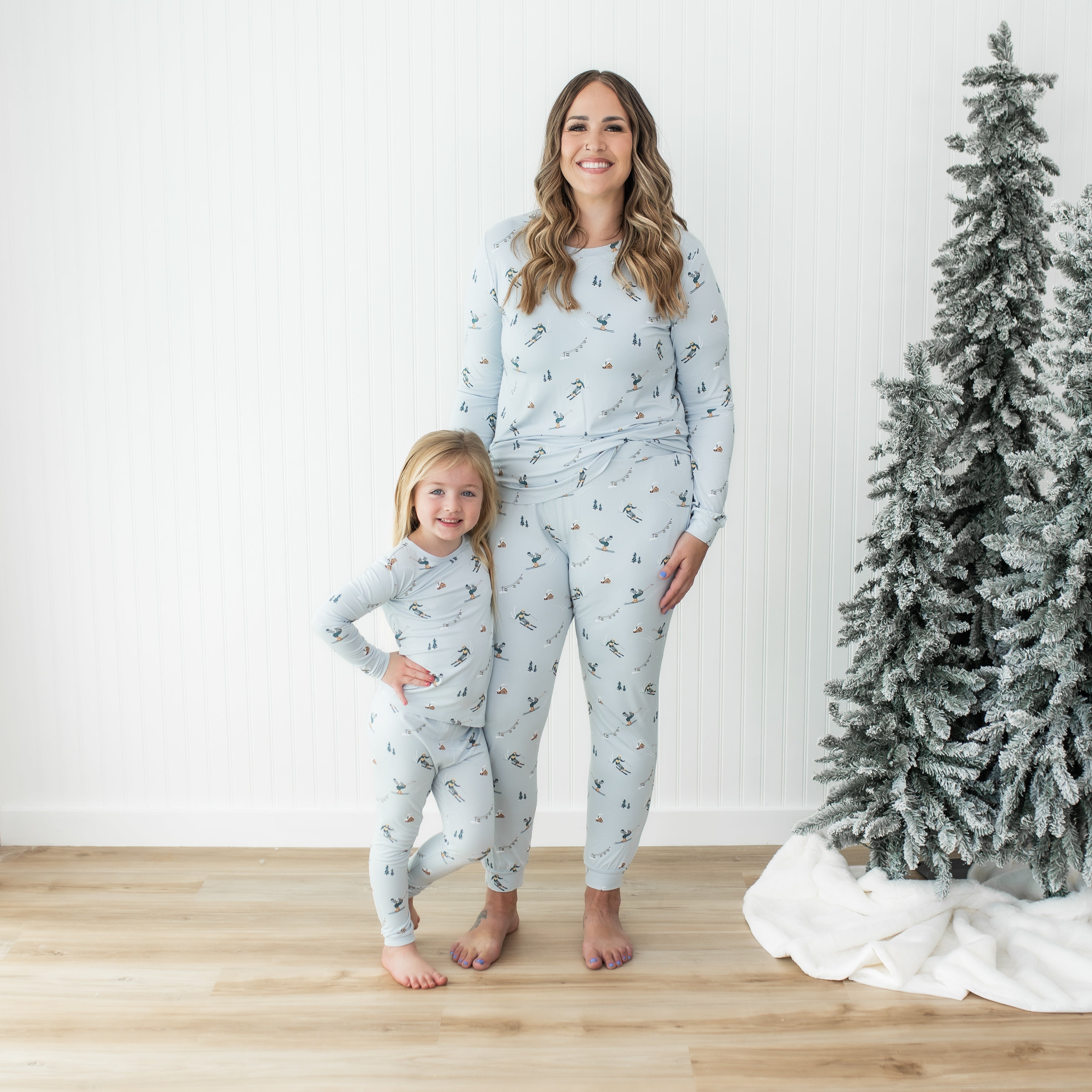Mother and daughter standing side by side both wearing matching pajamas in ski