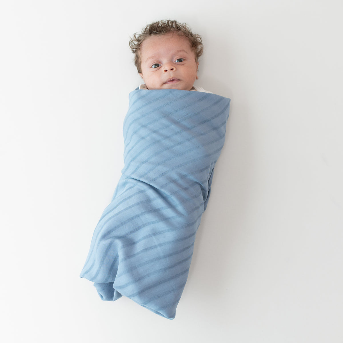 Baby wrapped in Bamboo Muslin Swaddle Blanket in Slate