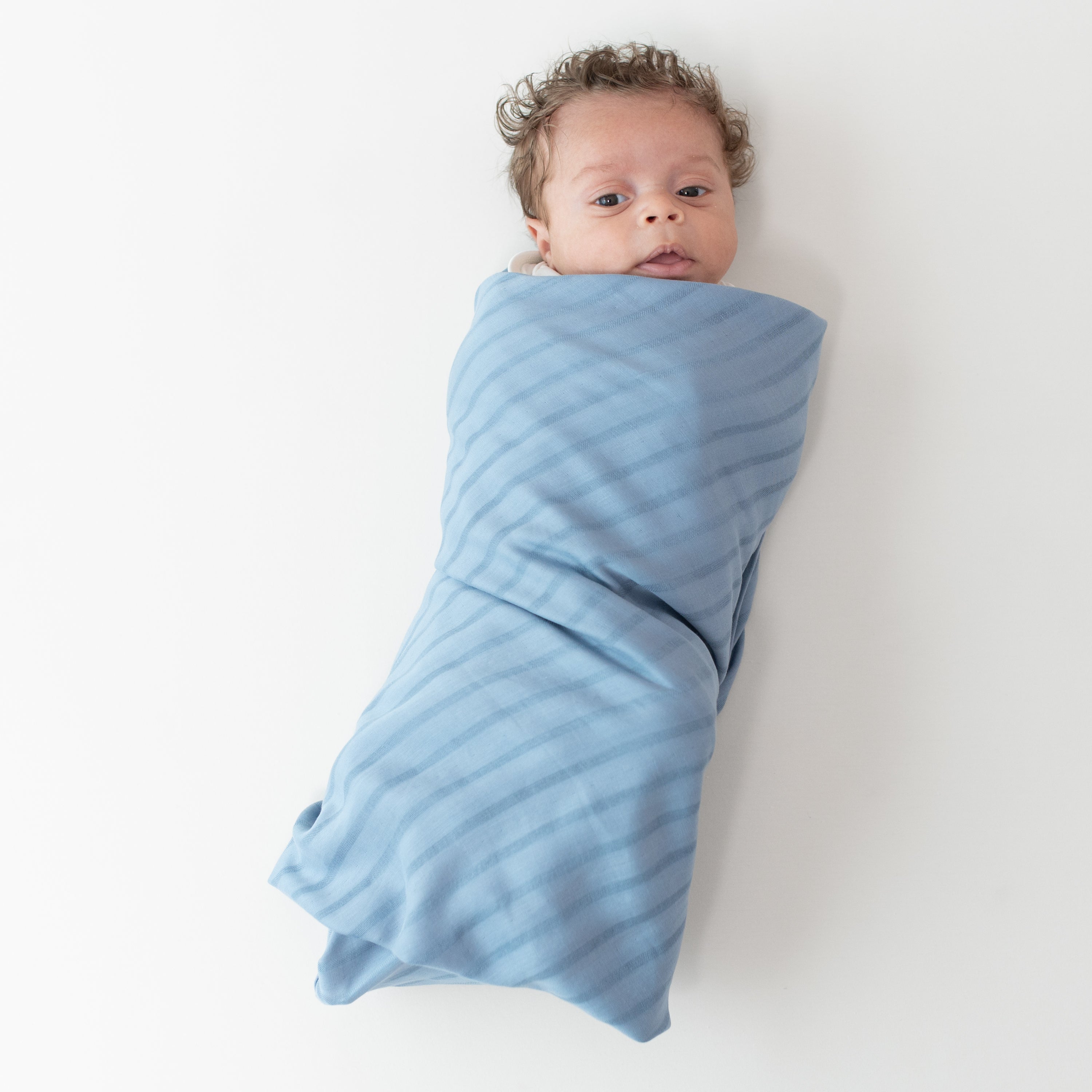 Baby swaddled in Blue Bamboo Muslin Swaddle Blanket in Slate
