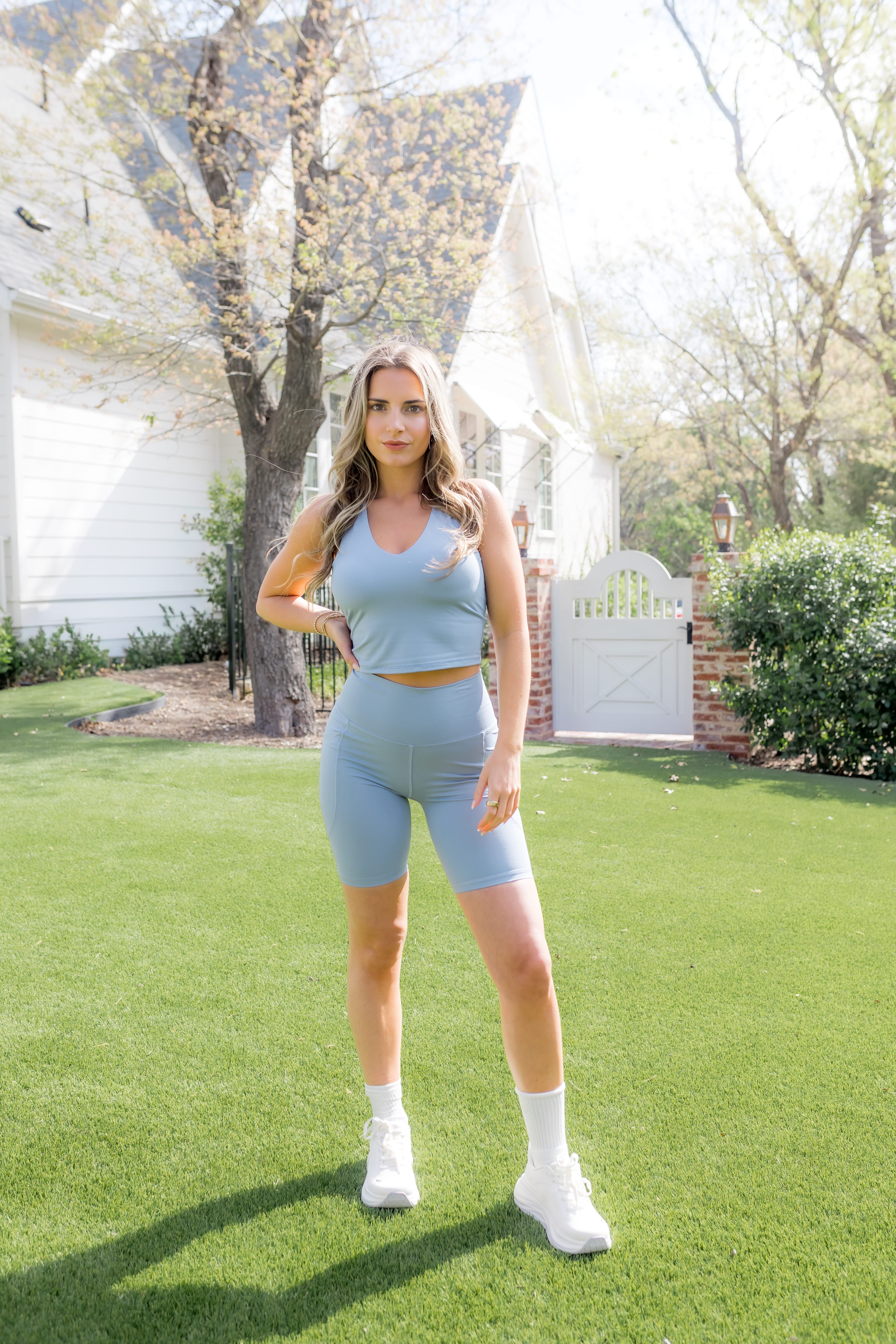 Female modeling the Bamboo Flex High Rise Biker Short in Slate paired with a matching bra tank