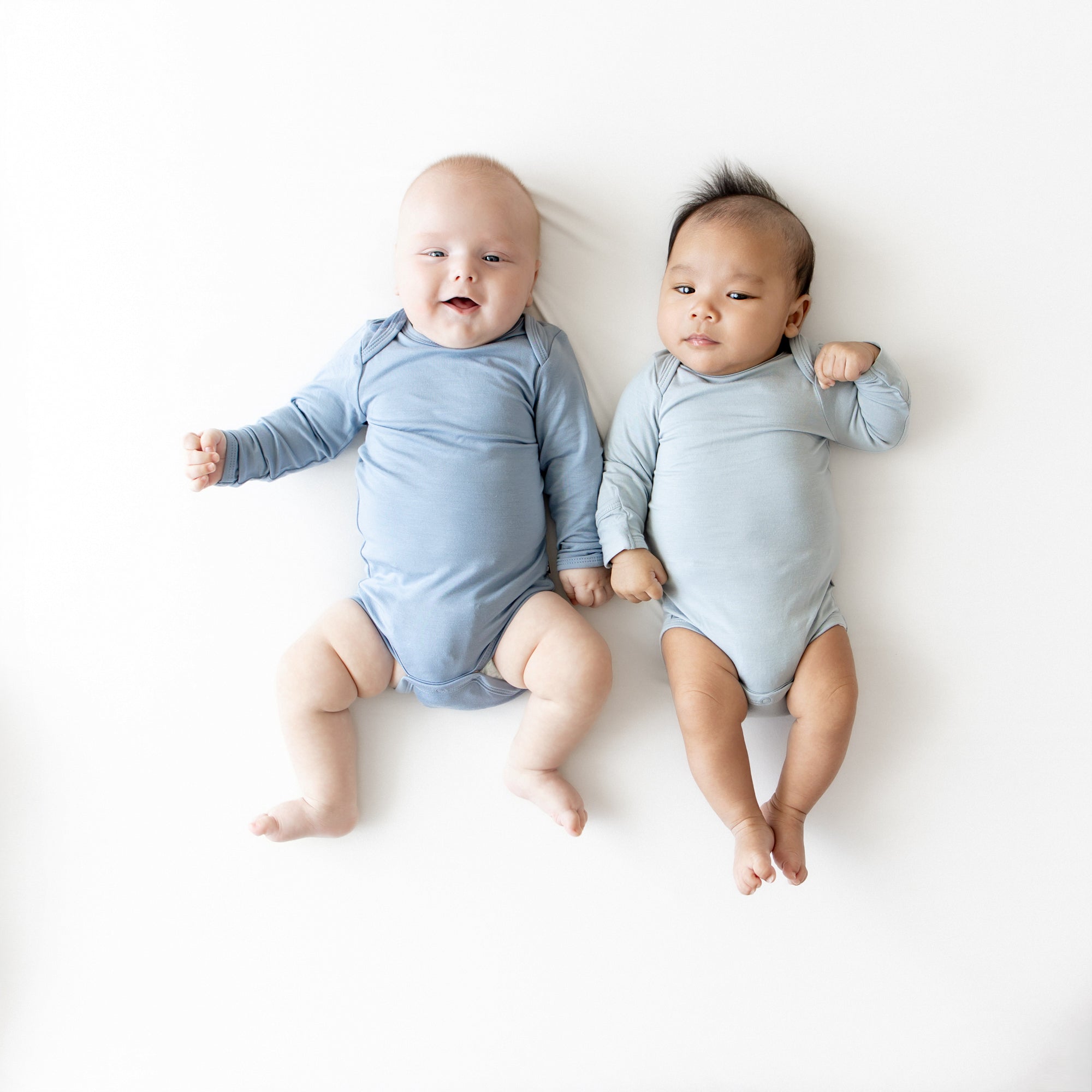 2 babies wearing Fog and Slate long sleeve bodysuits