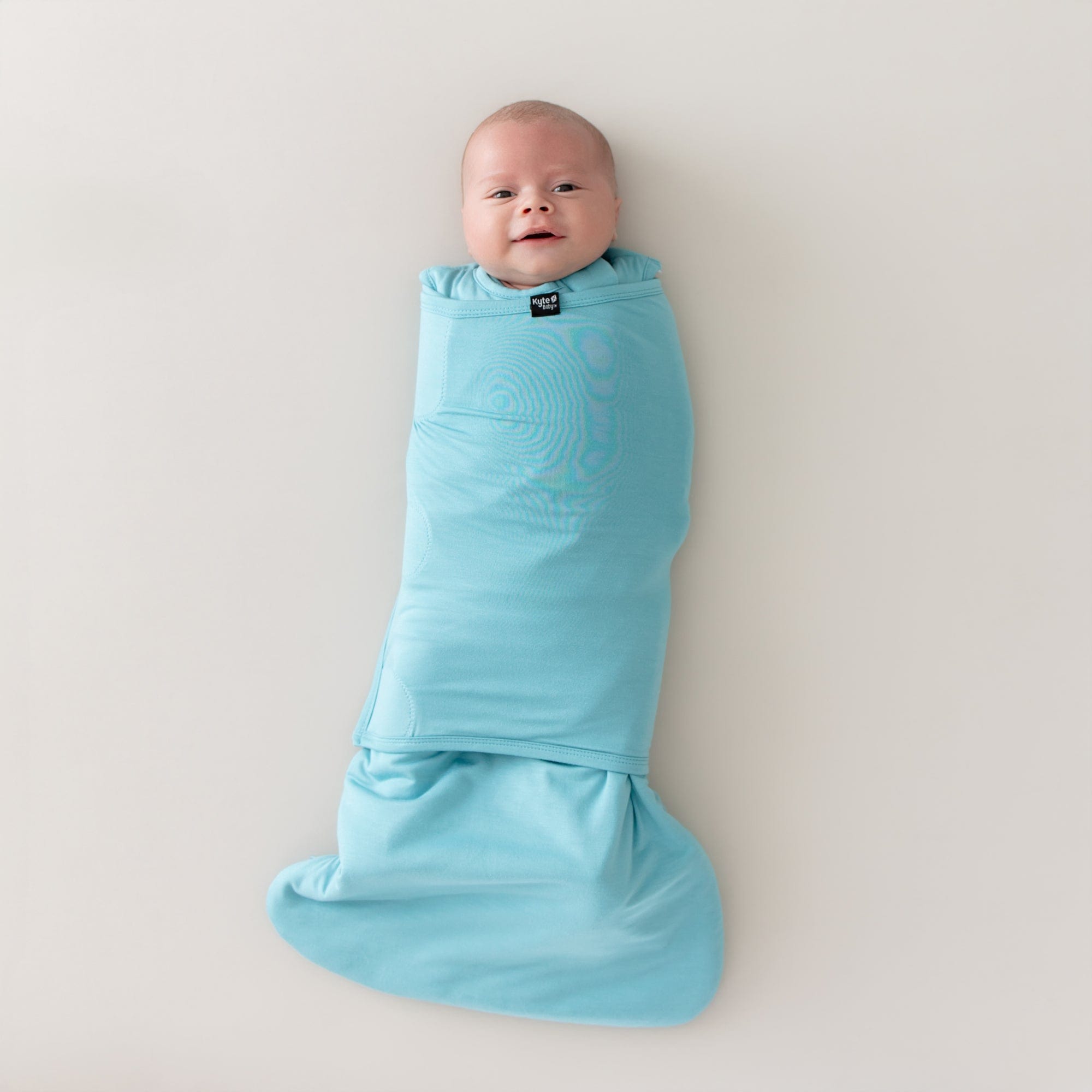 Baby swaddled in the Sleep Bag Swaddler in Makai 1.0