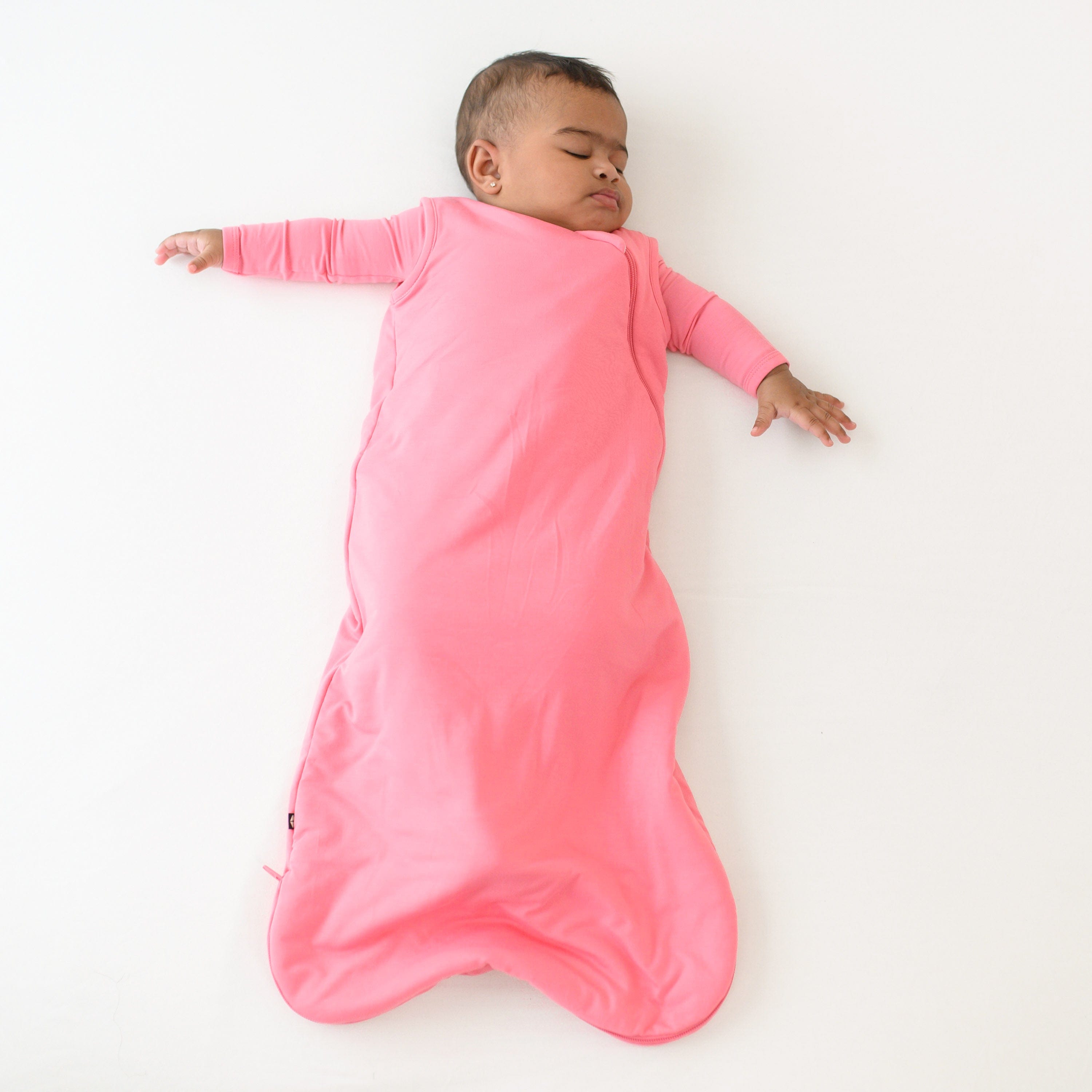 baby asleep wearing 1.0 sleep bag in guava