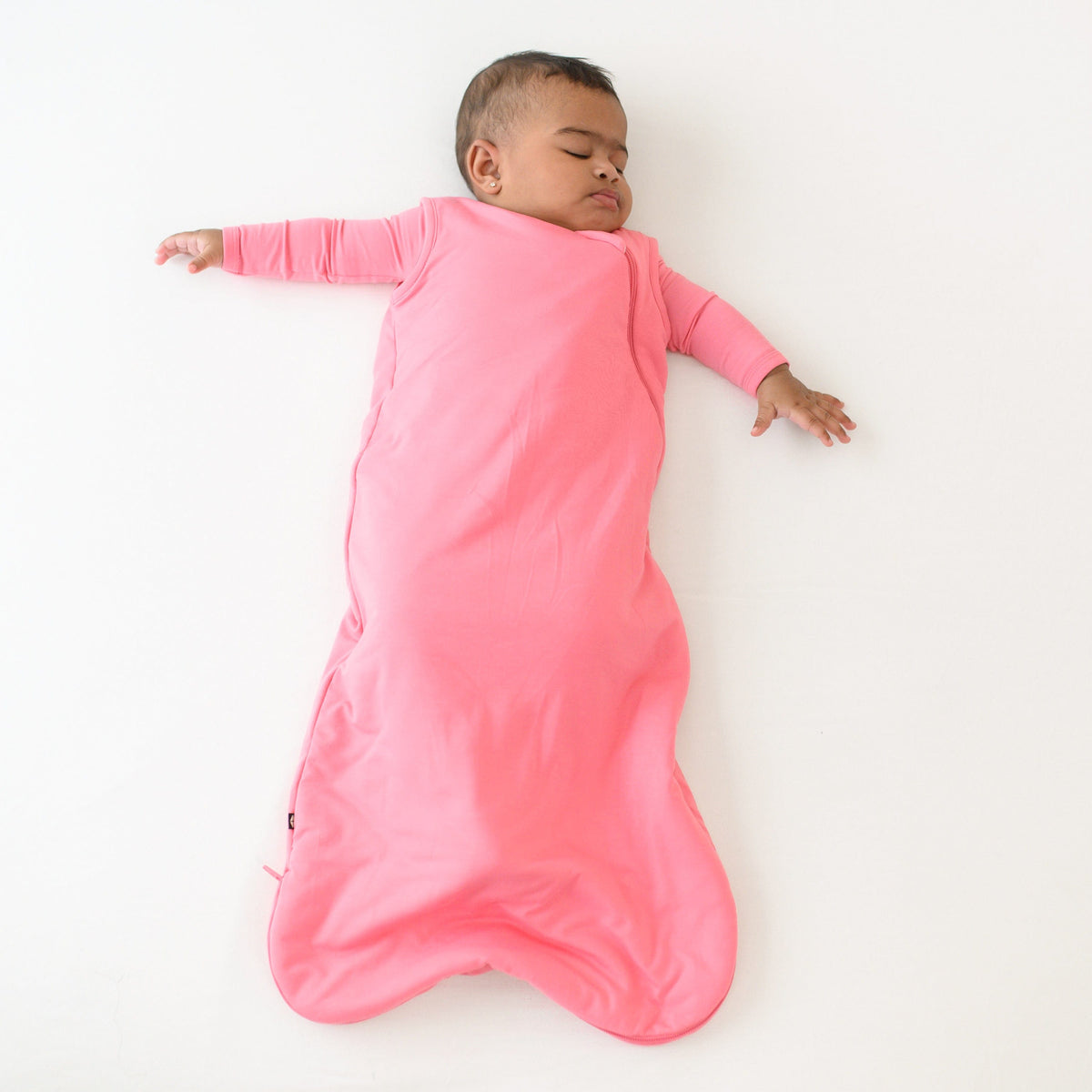 baby asleep wearing 1.0 sleep bag in guava