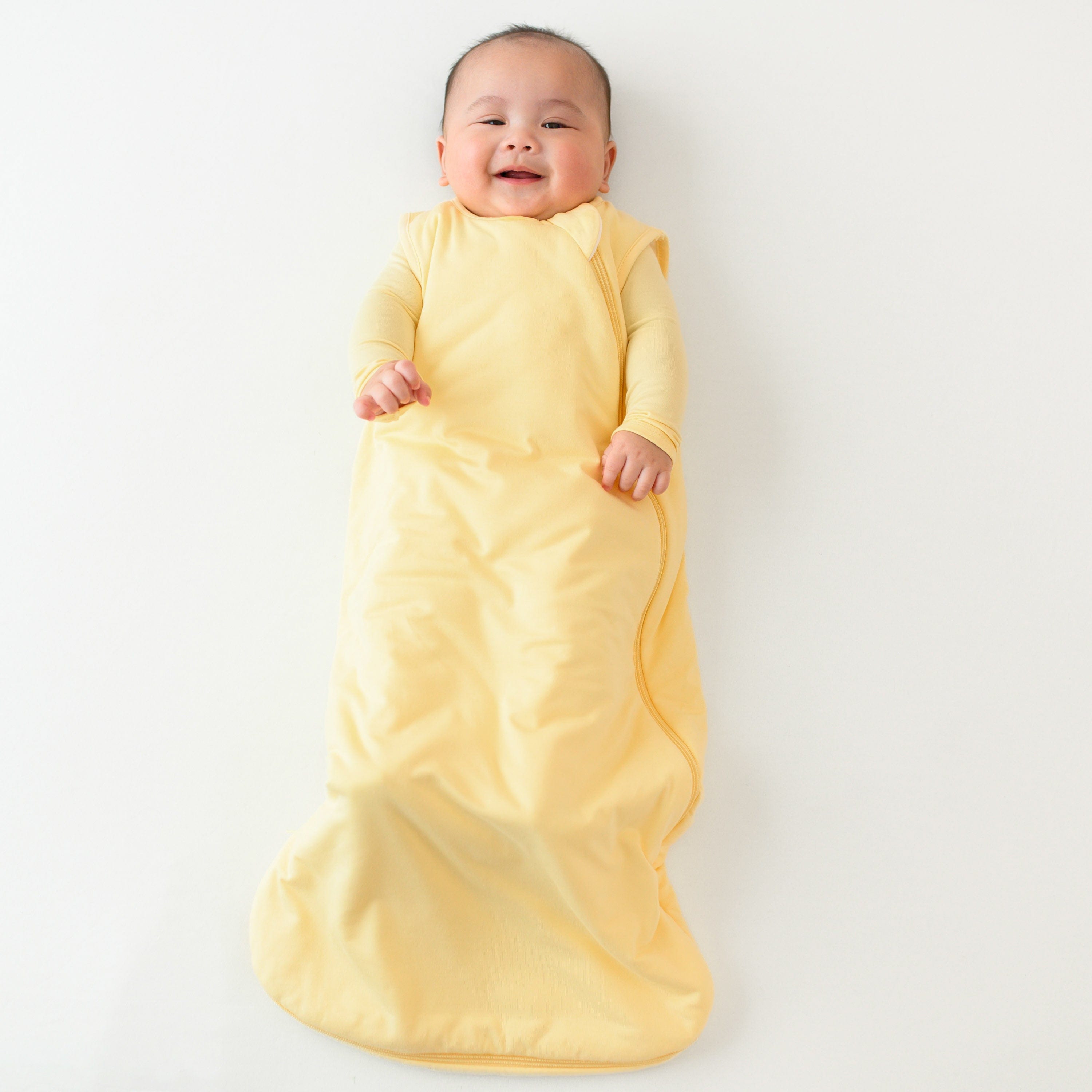 baby smiling while wearing kyte baby 1.0 sleep bag in lilikoi