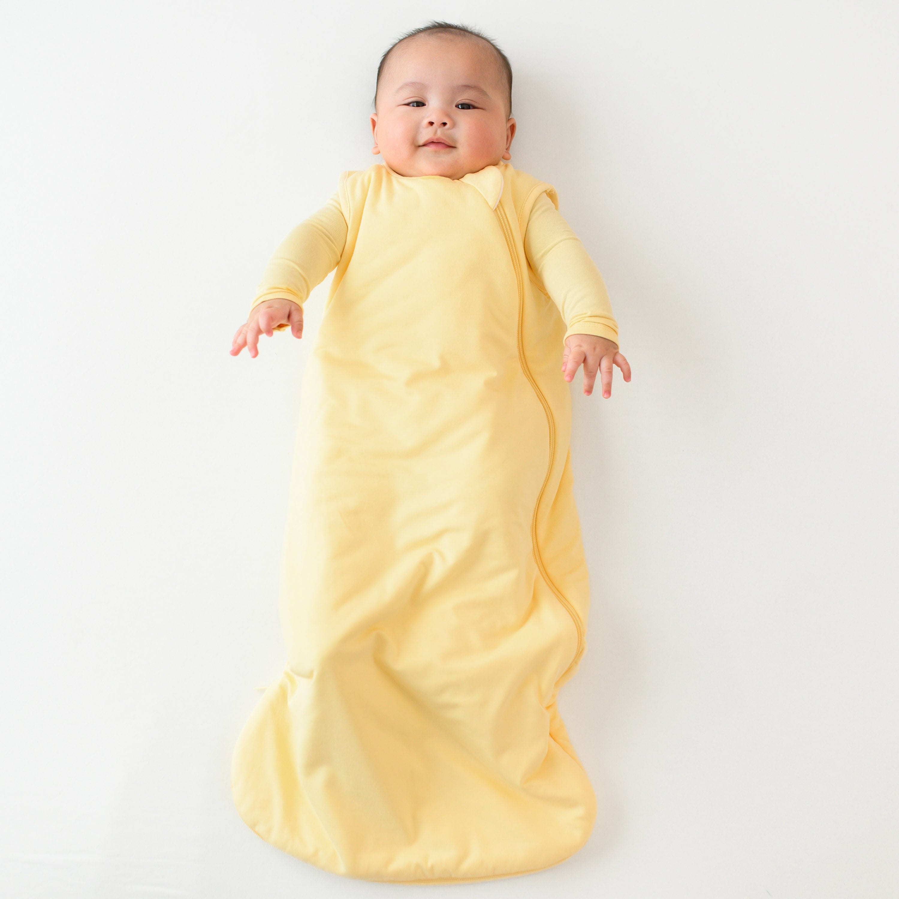 sleep bag in lilikoi on a laying baby