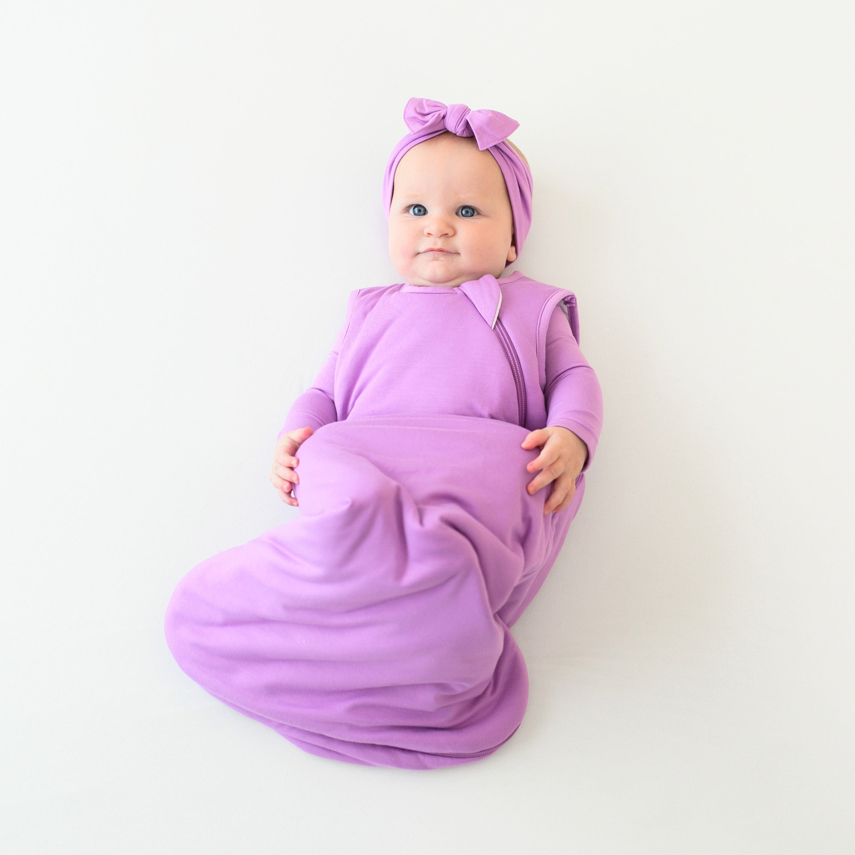 baby wearing kyte baby sleep bag 1.0 in poi with a Poi Bow