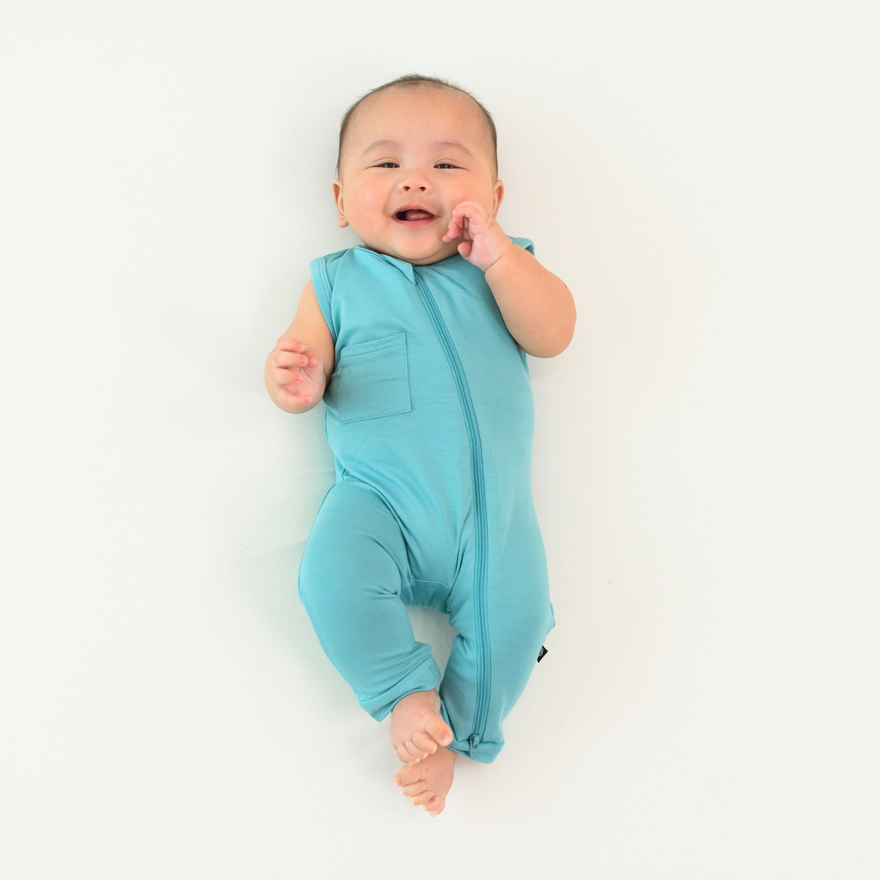 Infant wearing Kyte Baby Sleeveless Zippered Romper in Makai