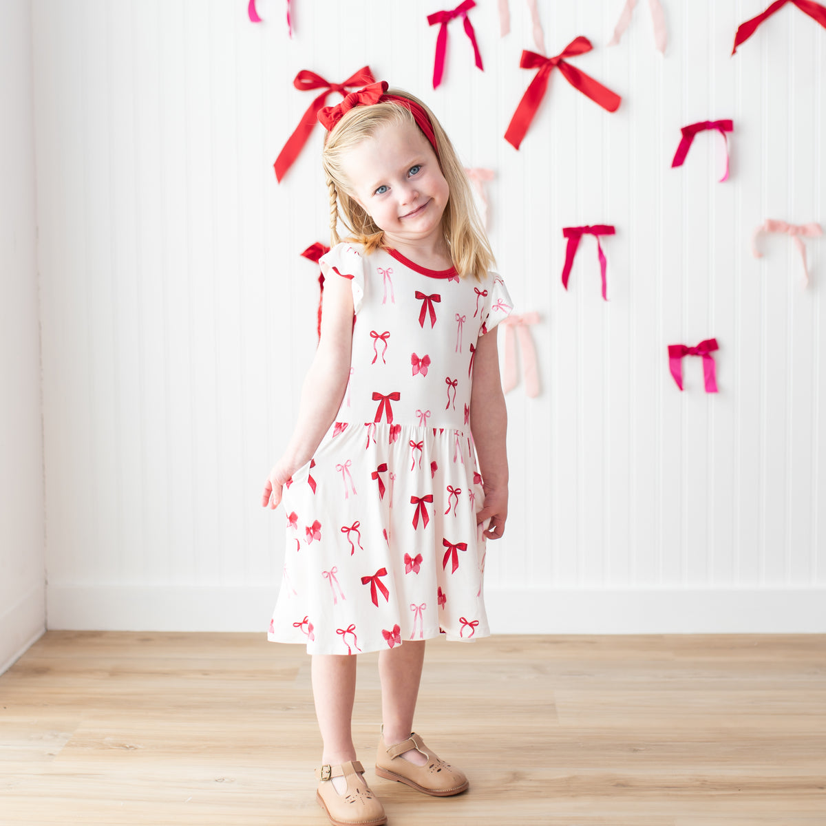 Young girl posing wearing the Pocket Dress in Small Love Bow